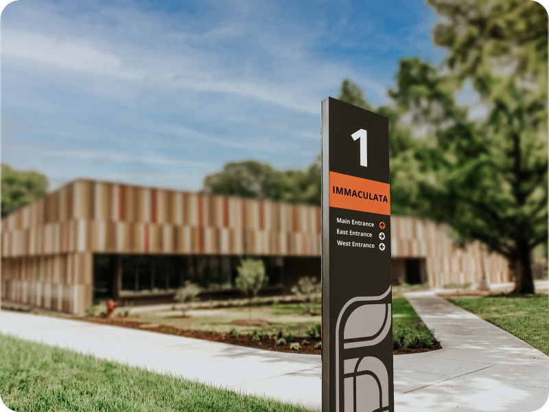 Exterior wayfinding signage in front of building.