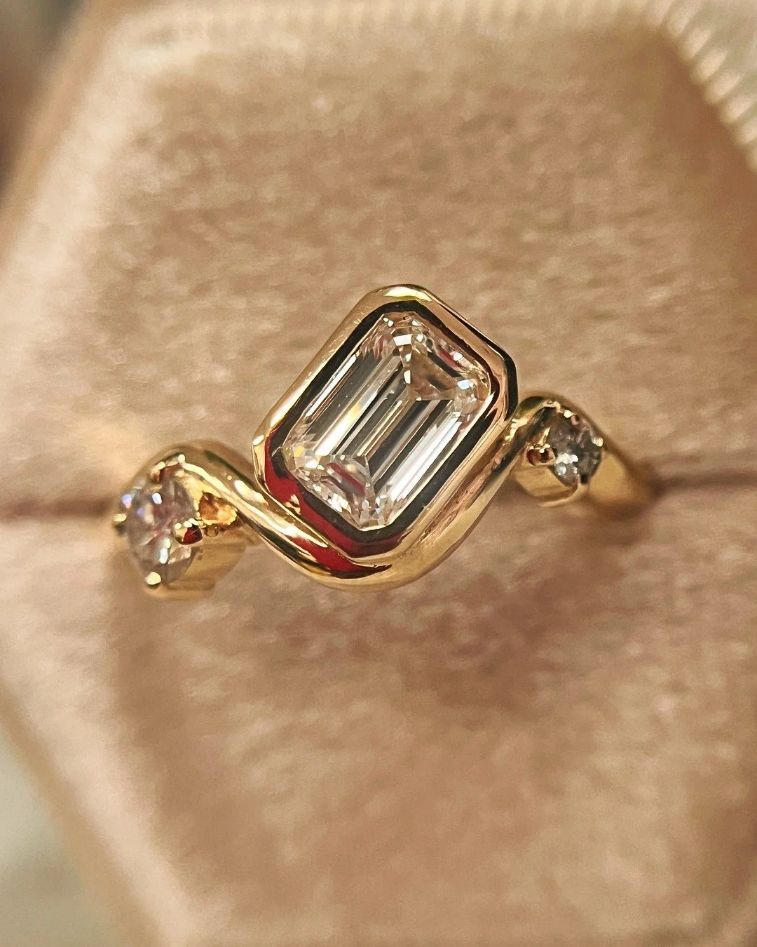 This one was FUN! Wavy, fluid engagement rings are all the rage these days, so when Molly and Peter reached out about custom I was really excited to try my hand at this unique style. Featuring a gorgeous one carat emerald step cut diamond flanked by 