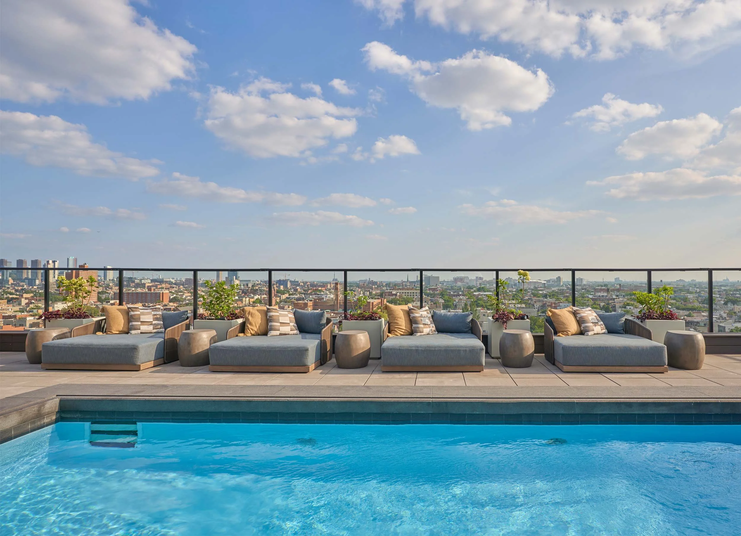 Double sun loungers on rooftop pool deck.
