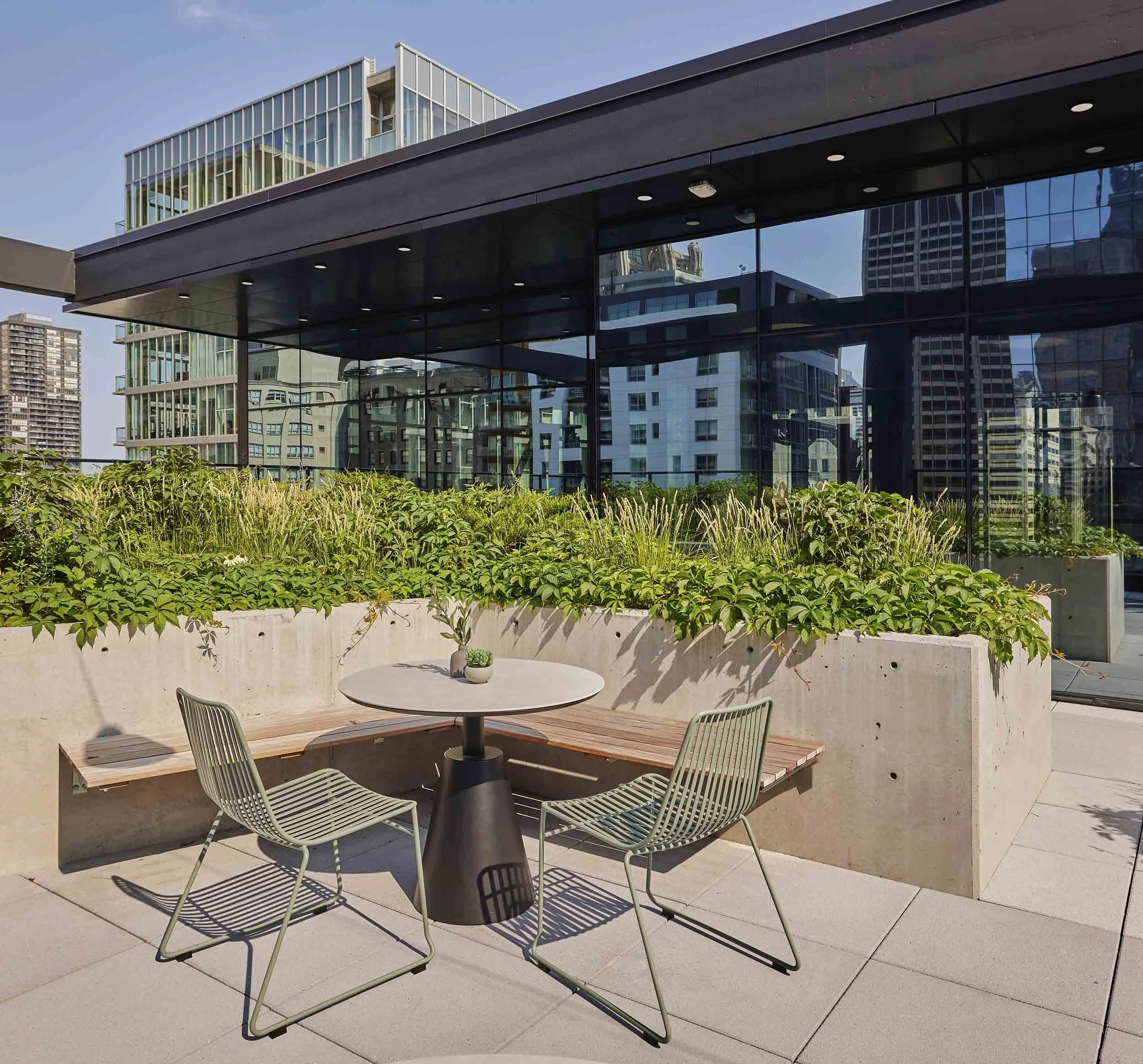 Built-in concrete form planters bench seating on an urban rooftop
