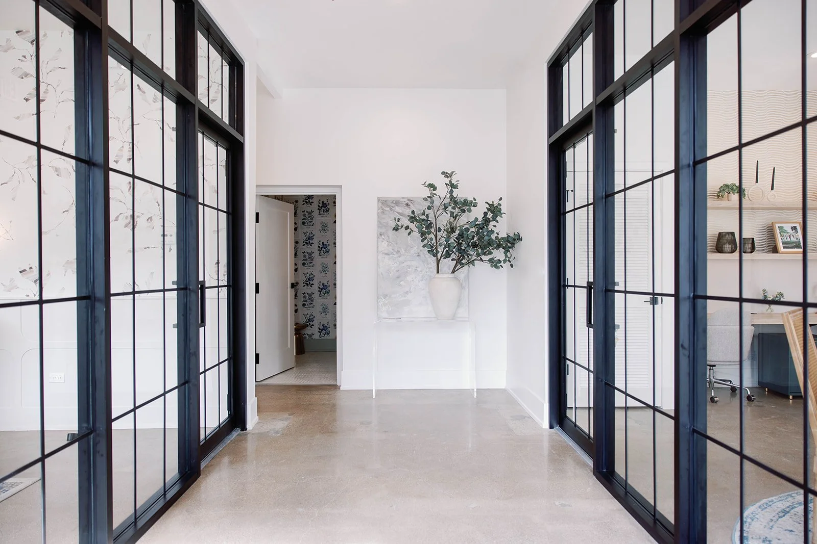 Entrance corridor with black metal and glass walls and concrete floor
