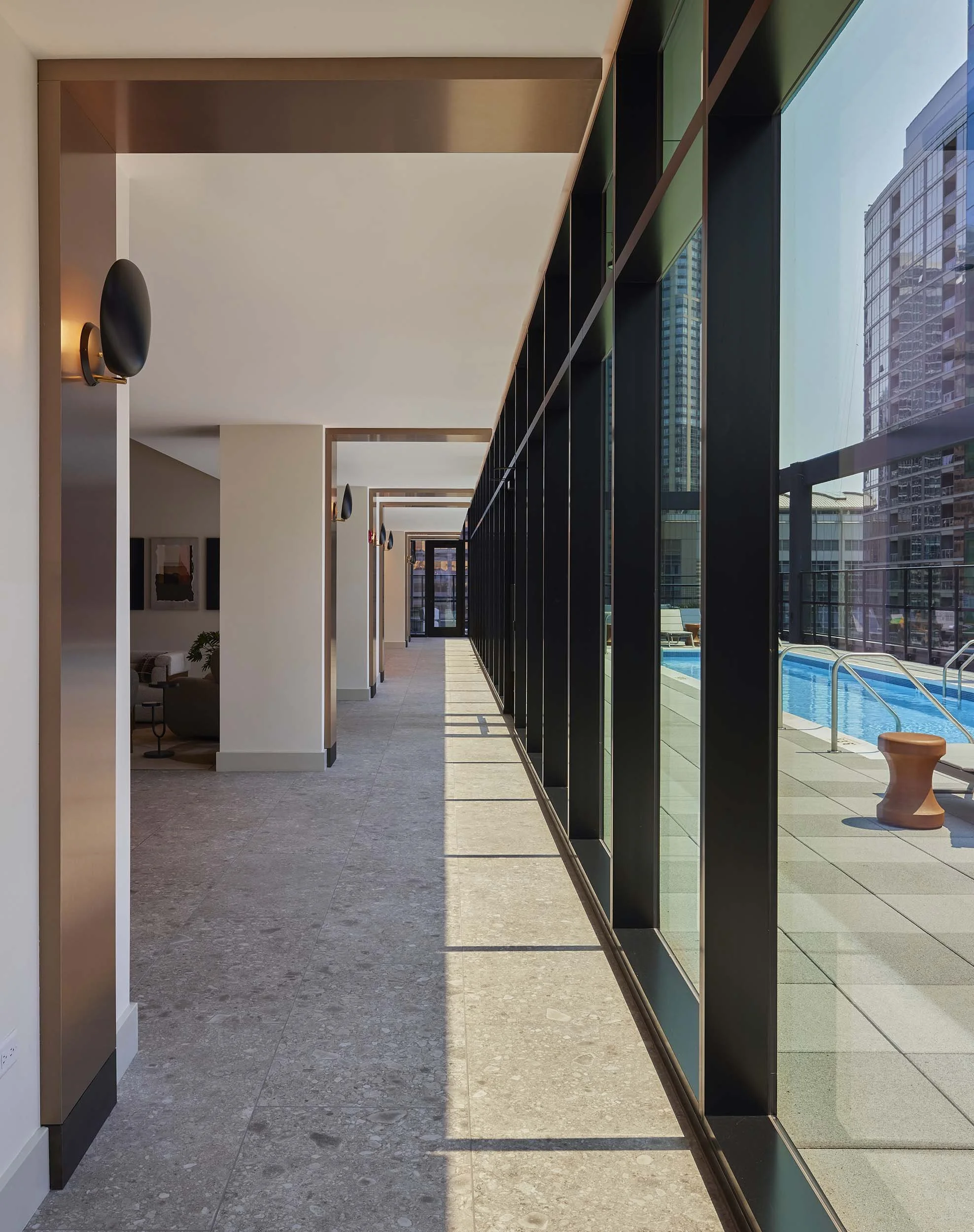 Corridor with rhythmic columns and window wall to rooftop pool