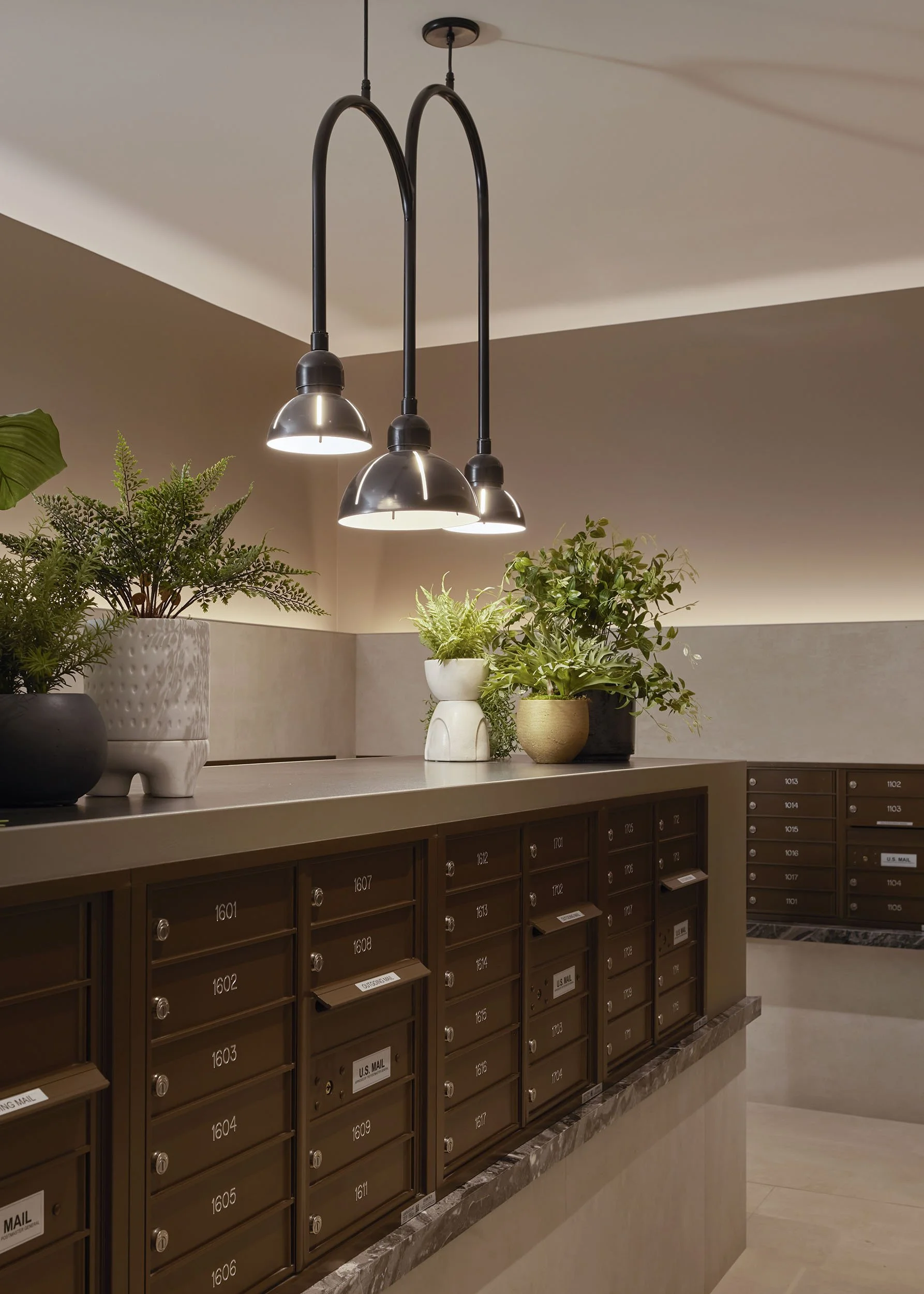 Sophisticated mailroom with arched pendant and potted plants