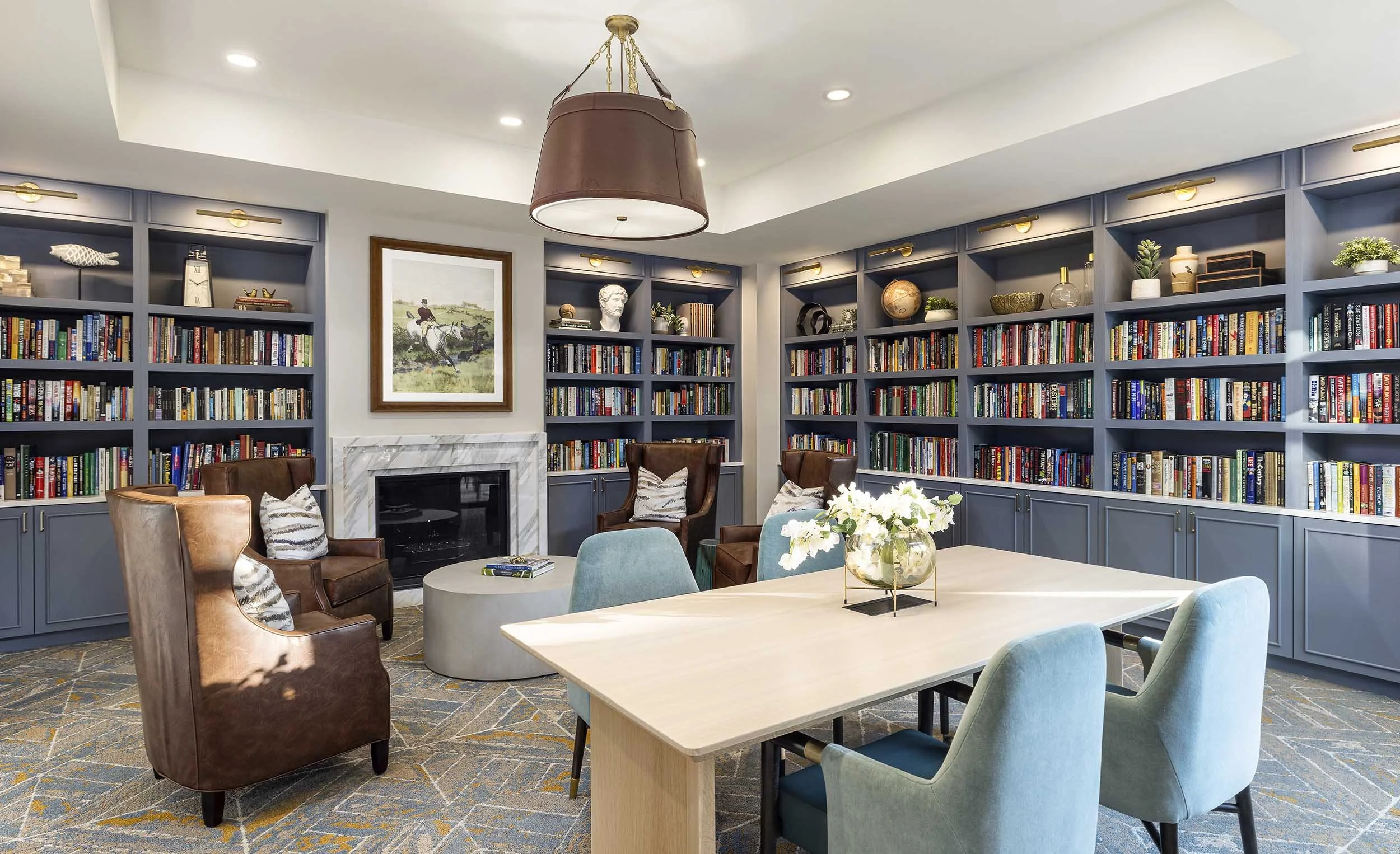 Resident library with fireplace, dusty blue, shelving, leather light fixture
