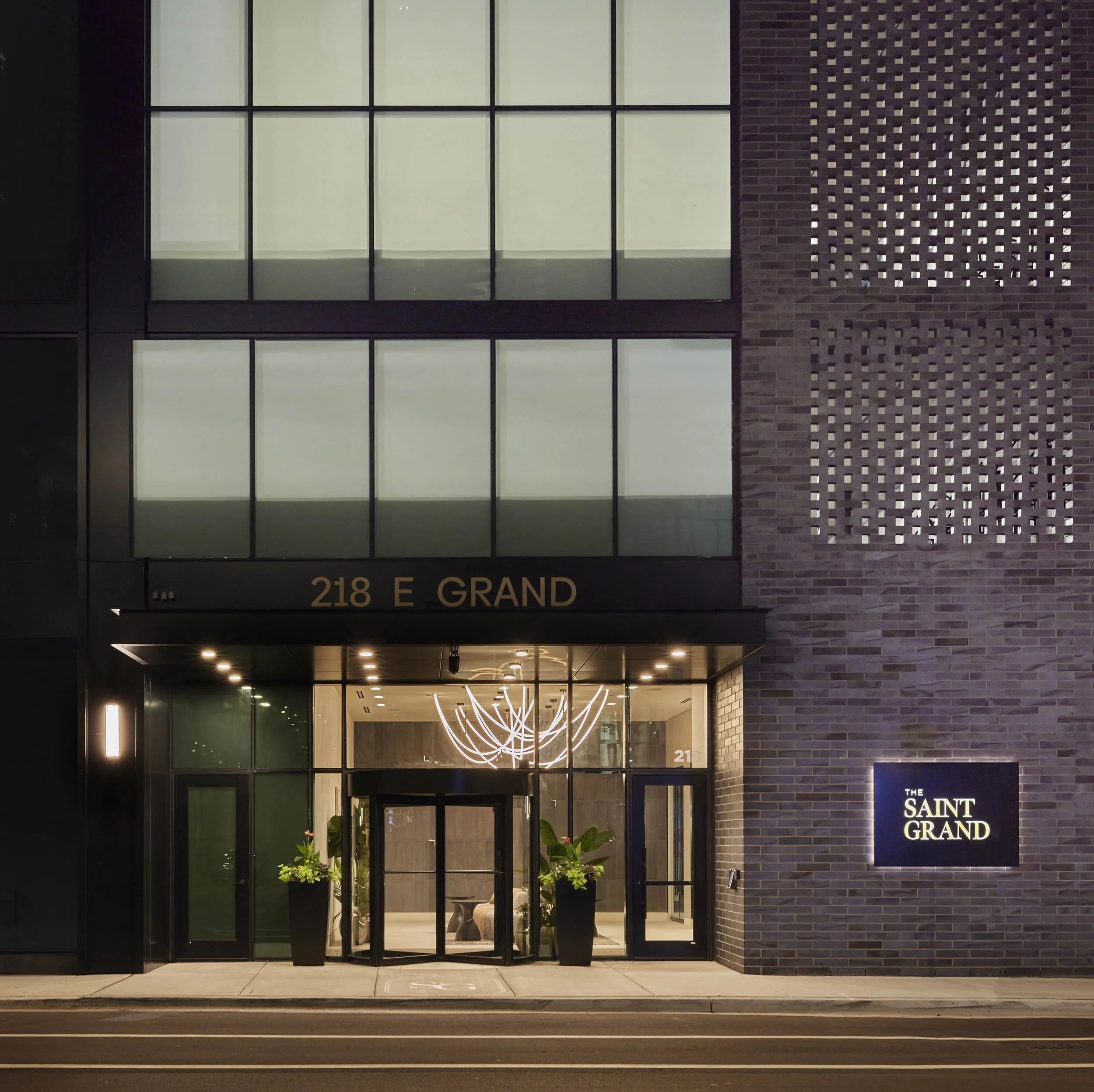 Dark gray brick exterior with golden light and chic signage