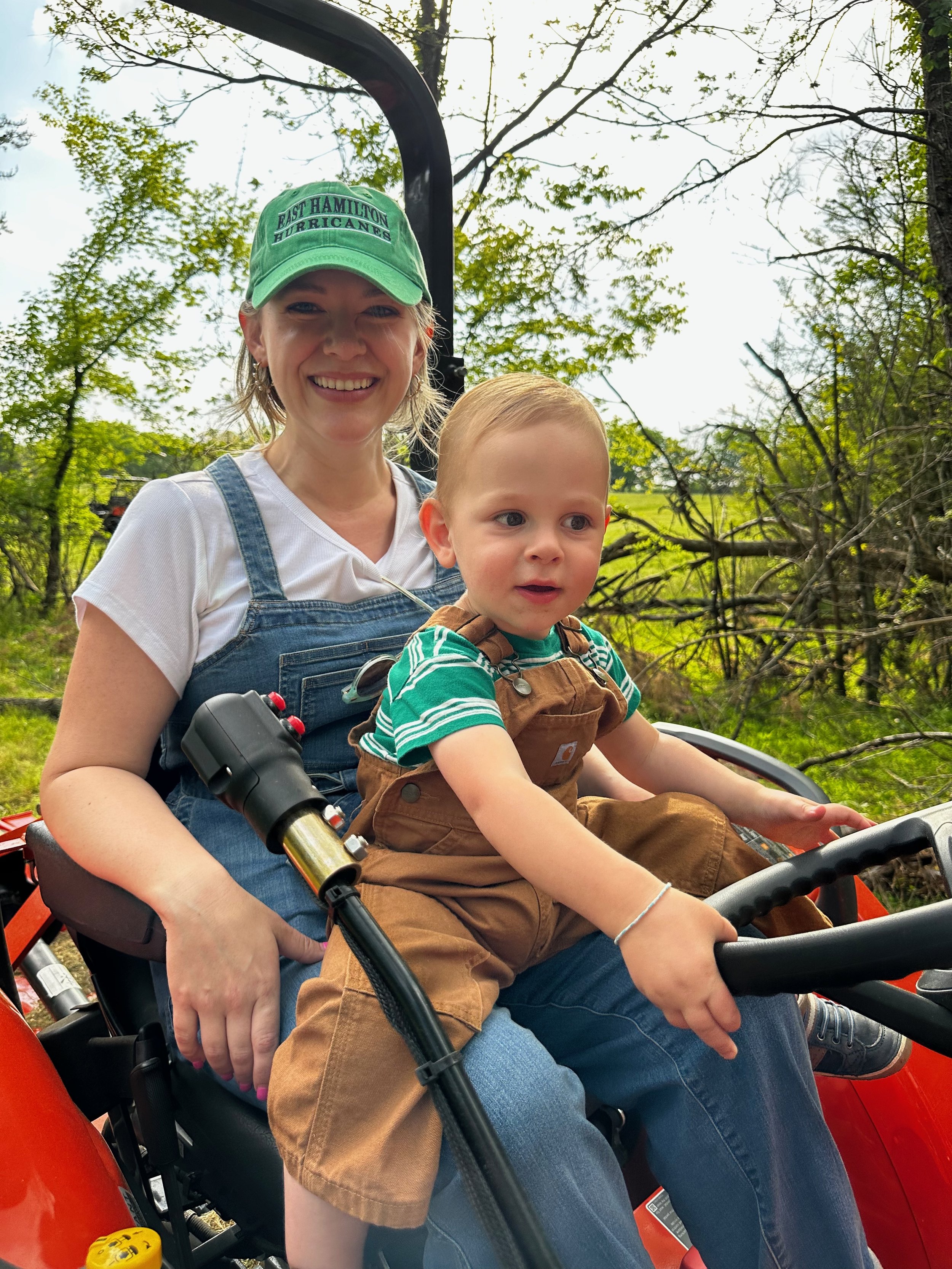 Woman and young boy on farm tractor smiling