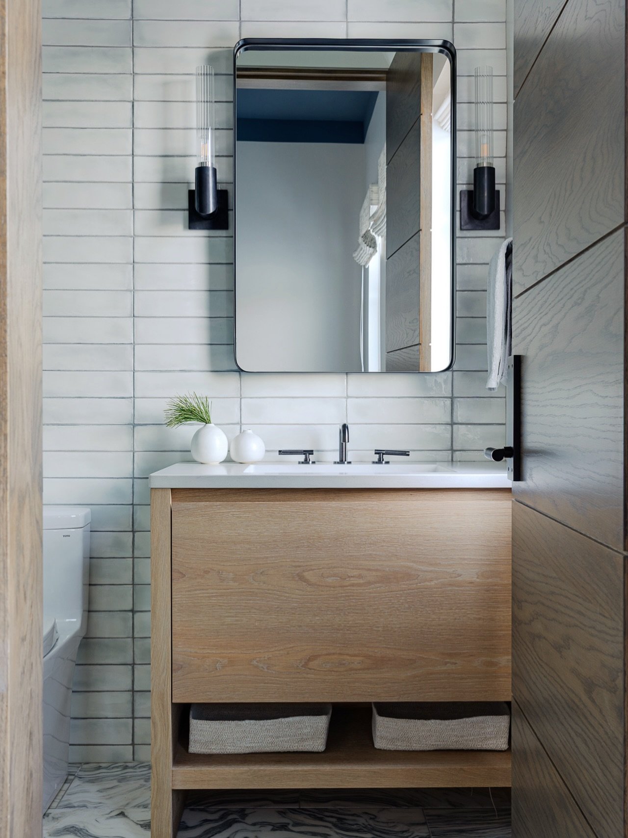 Warm oak and icy white tiles bring the outdoors in at our Spruce Modern Ski home. Immersing you into the snowy Stowe lifestyle. Edgy, cool, and rugged. ⁠ #KennerknechtDesignGroup⁠
⁠
#interiordesign #interiordesigner #skihouse #bathroomdesign