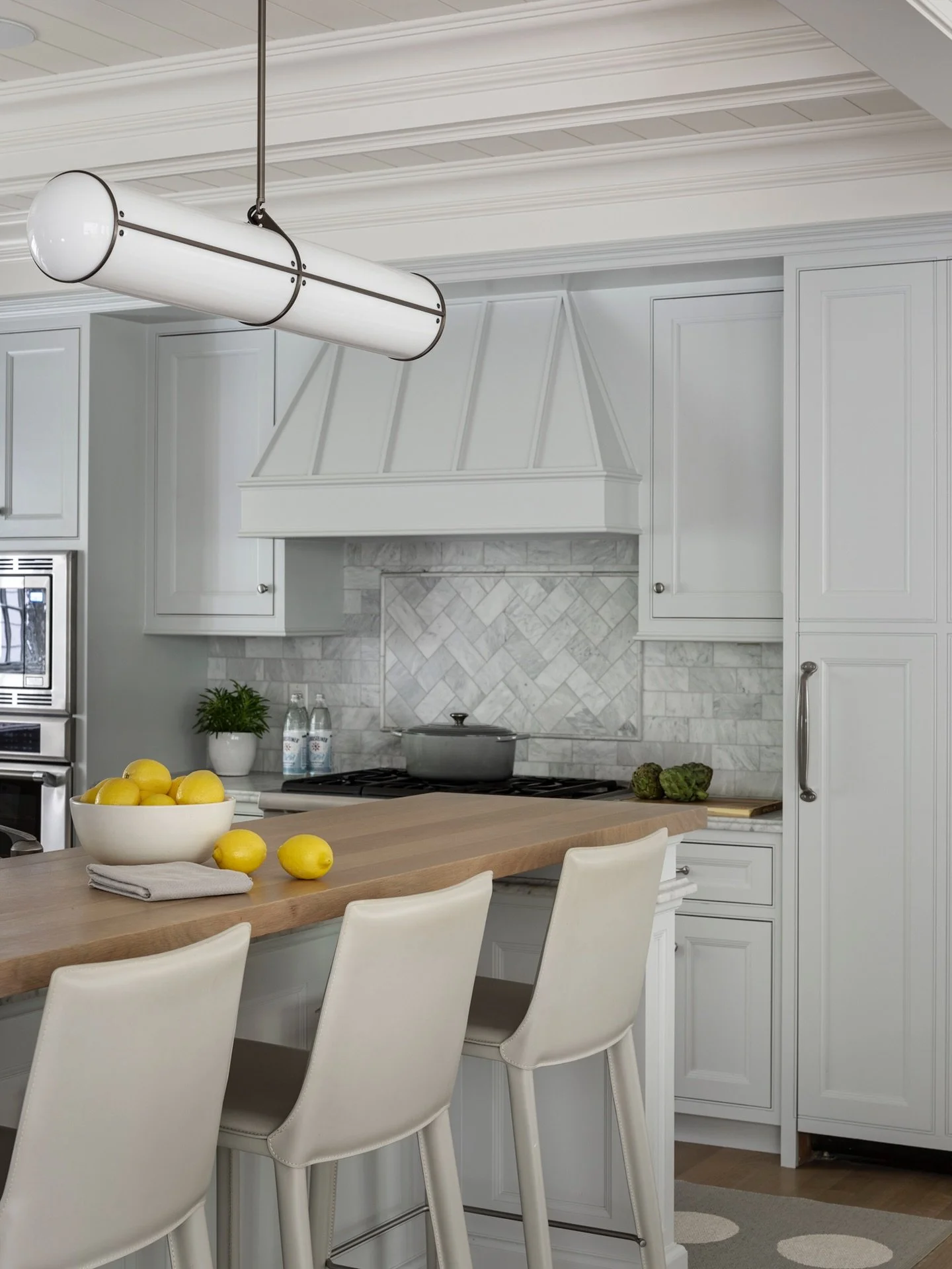 Linear lighting and leather-wrapped stools revamp the heart of this Newton home. ⁠We gave the cabinetry a fresh coat of soft blue paint to complete this clean contemporary look. #KennerknechtDesignGroup⁠
⁠
#kitchen #kitchendesign #interiordesign #int