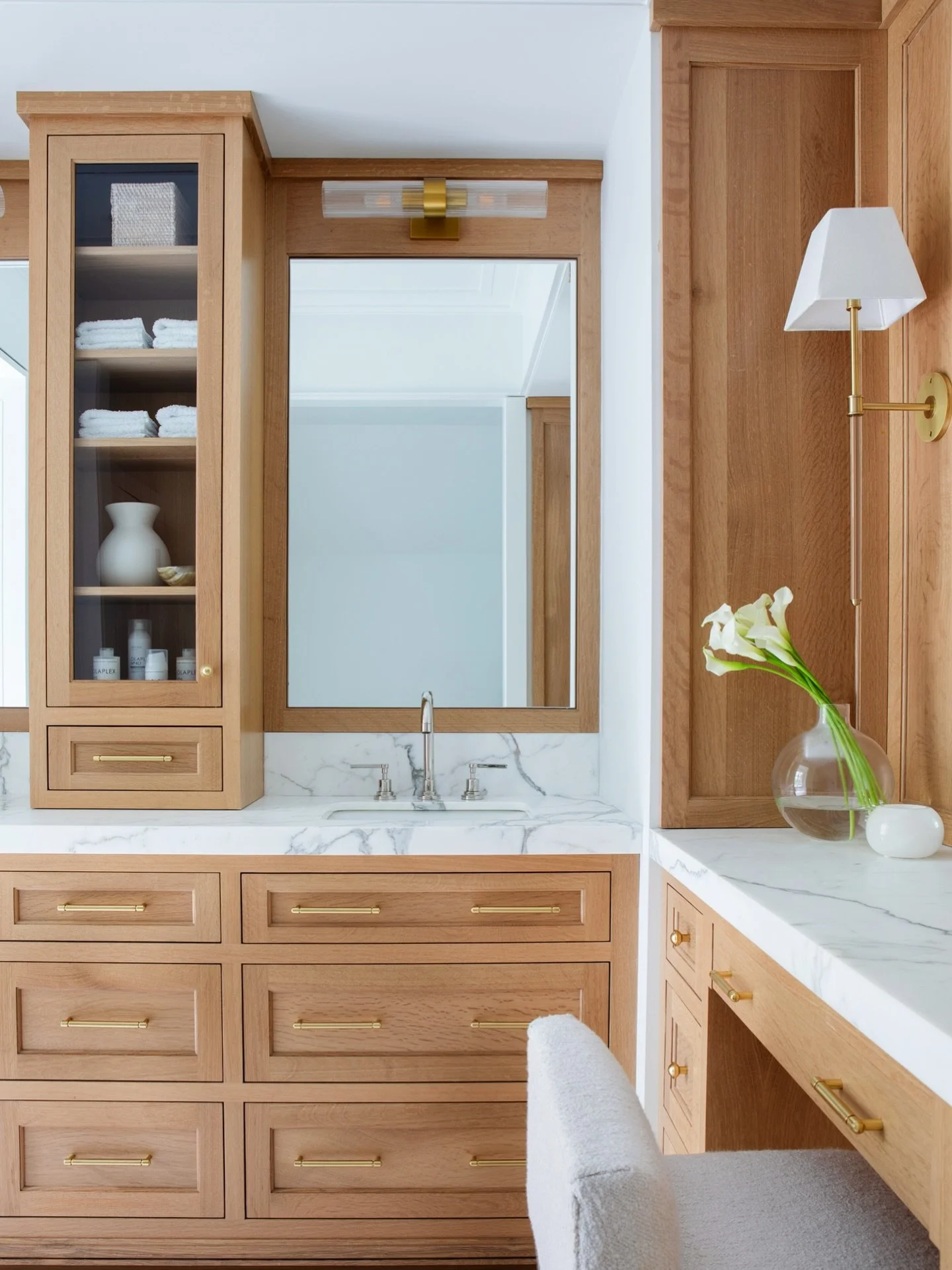 Classic oak cabinetry complements clean marble for a timeless look. Light fixtures were carefully chosen here to add a luxurious feel. Serene, sophisicated and the perfect place to start off your day fresh. #KennerknechtDesignGroup⁠
⁠
#bathroomdesign