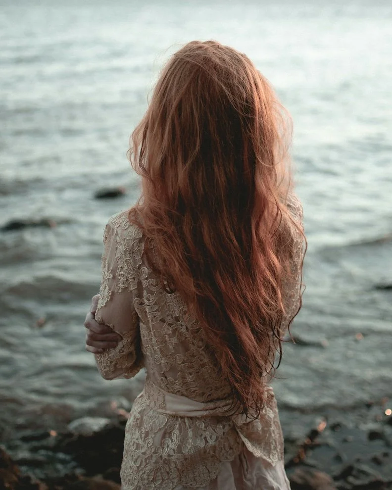Woman gazing at the ocean representing the self reflective aspects of grieving and healing