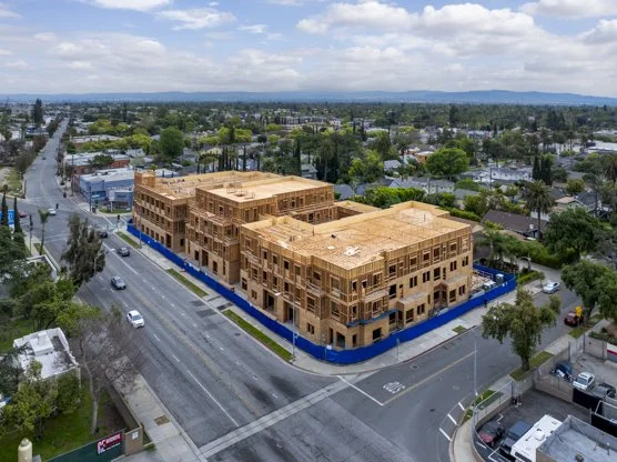 Scenic landscape of mountains and a body of water with grassy hills in the foreground and overcast sky.
