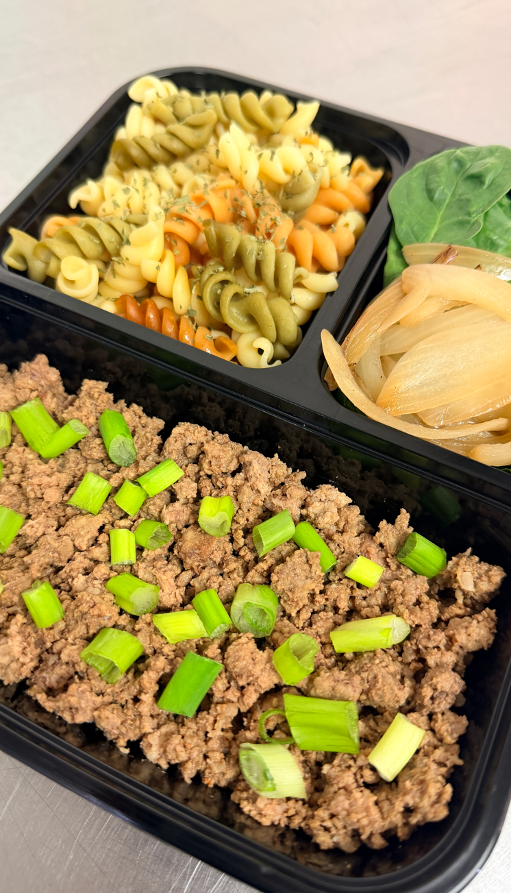 Ground beef with green onions, tri-color rotini pasta and sautéed onions with spinach