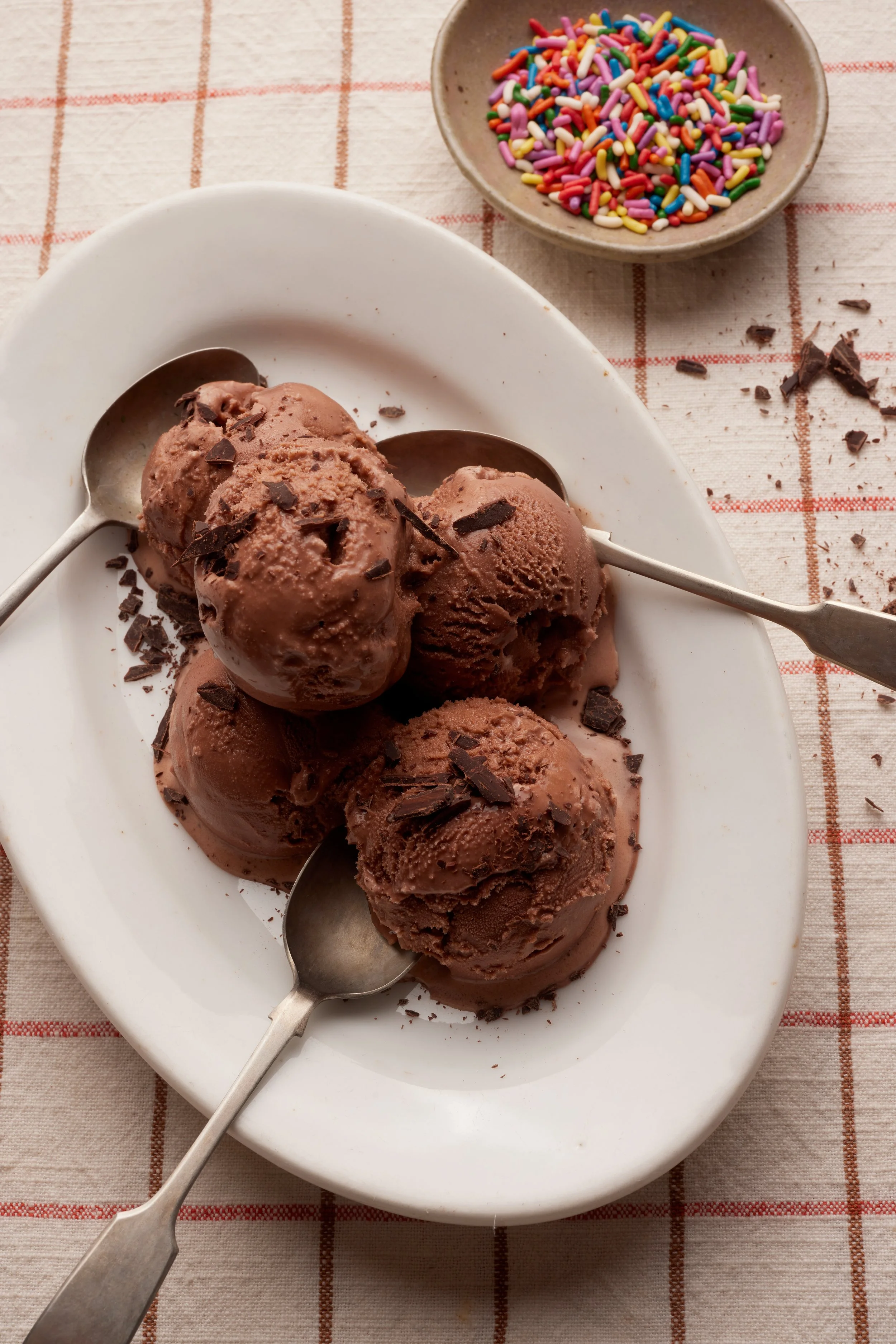 Four scoops of Lacock Dairy chocolate ice cream topped with chocolate shavings showcasing premium food photography