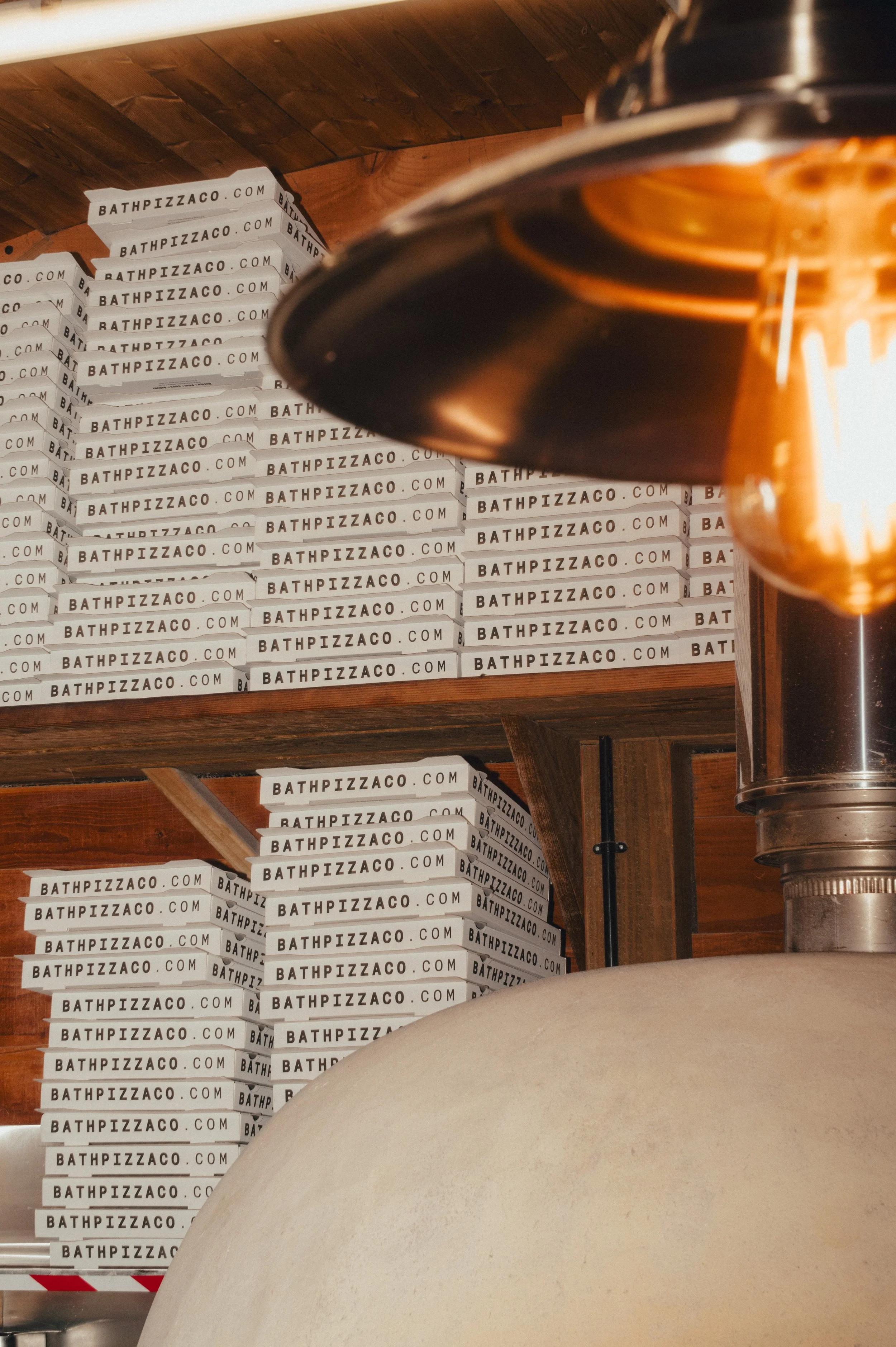 Photography of Bath Pizza Co featuring their branding on pizza boxes