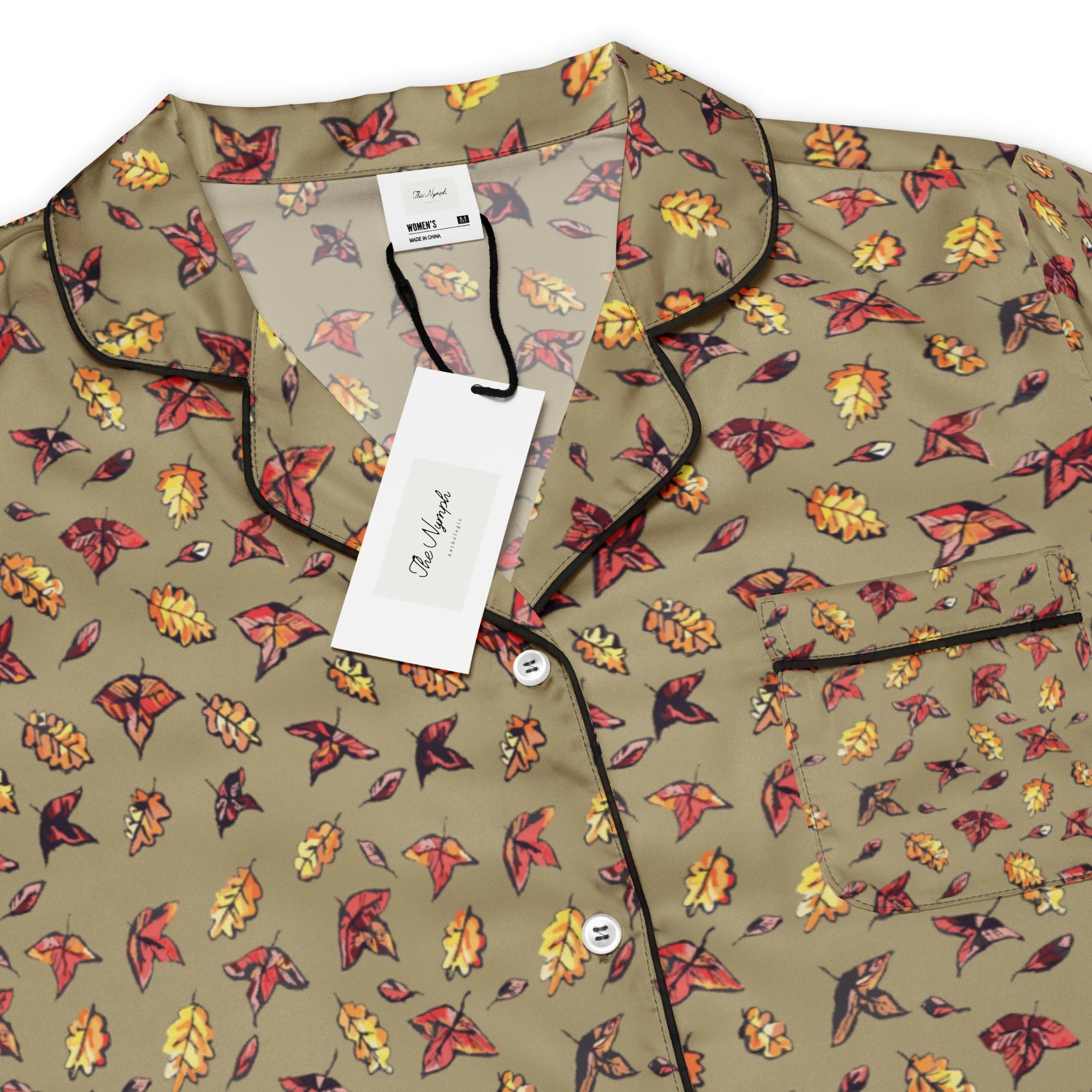 Close-up of the Green Falls pyjama top's collar, buttons and red and yellow autumn leaf print on olive fabric