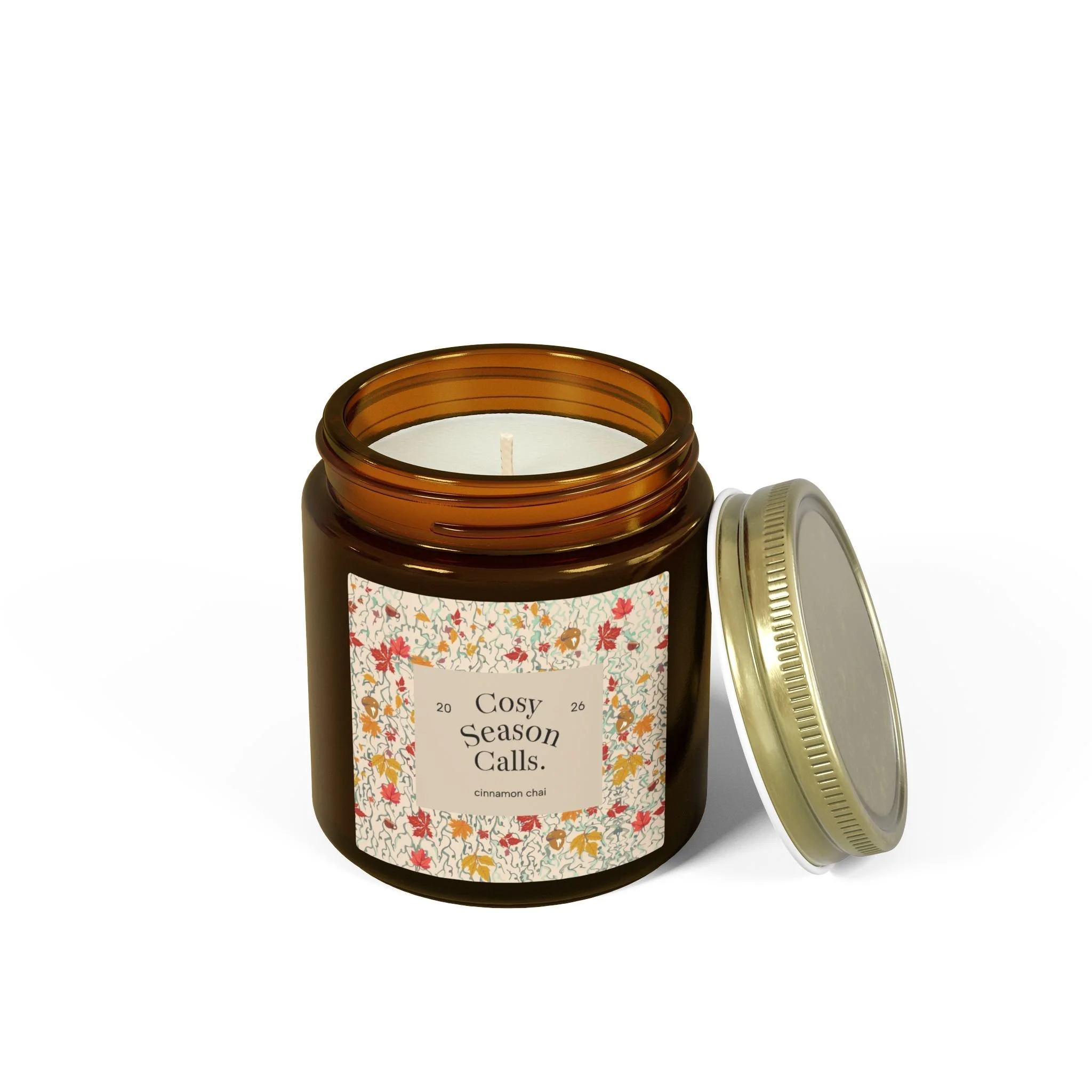 Open Cosy Season Calls cinnamon chai candle in amber glass with its gold lid set aside