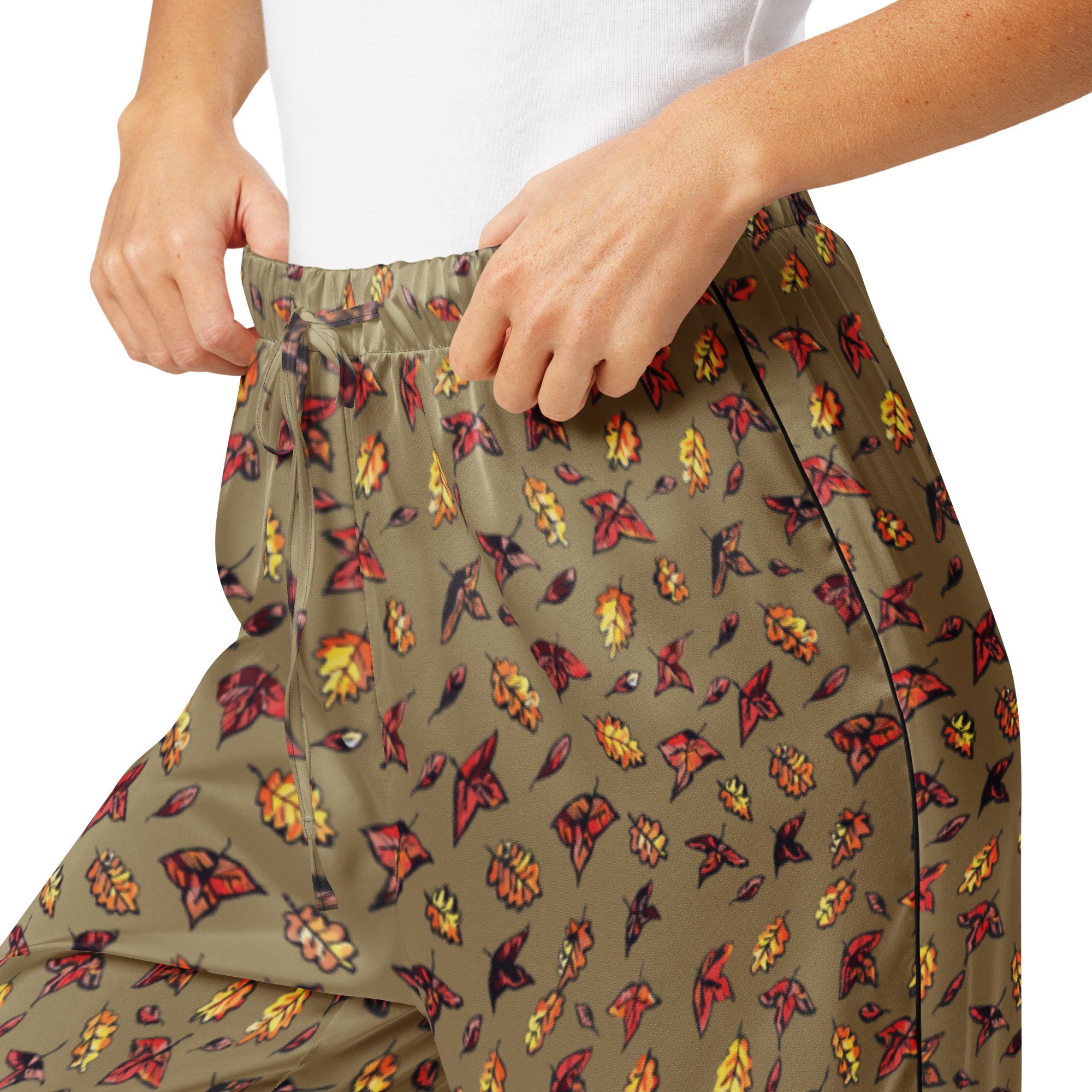 Close-up of the Autumn Green pyjama trousers' elastic waist and red and yellow autumn leaf print on olive fabric