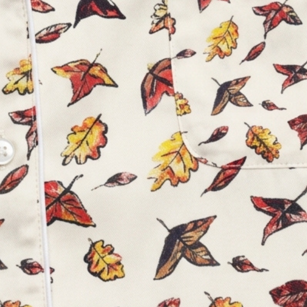 Close-up of the Autumn Chills autumn leaf print in red, orange and yellow on white fabric