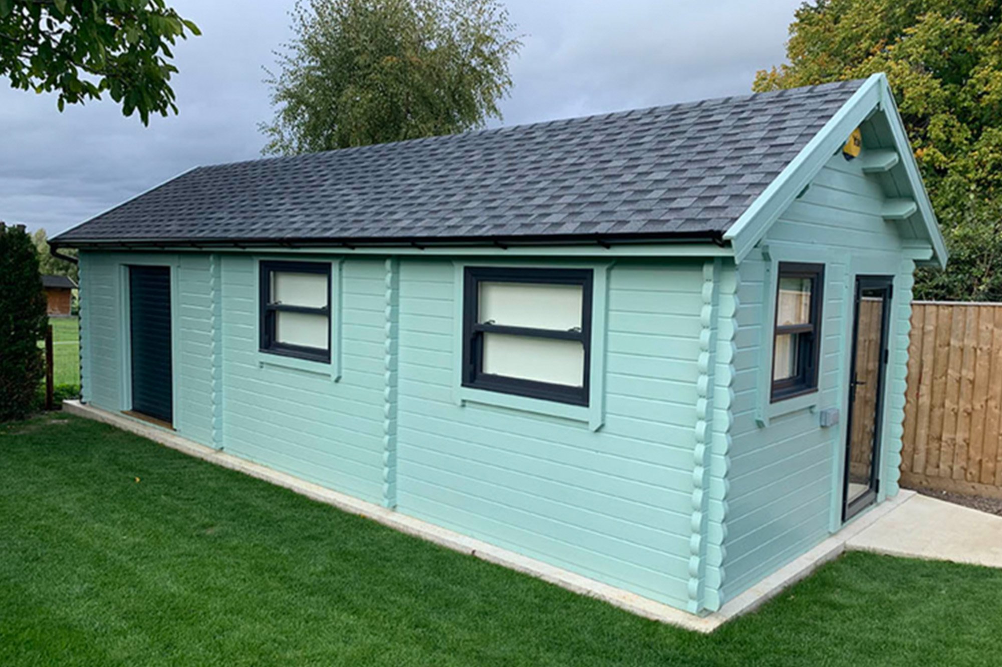  Log cabin workshop with steep roof and roller shutter door 