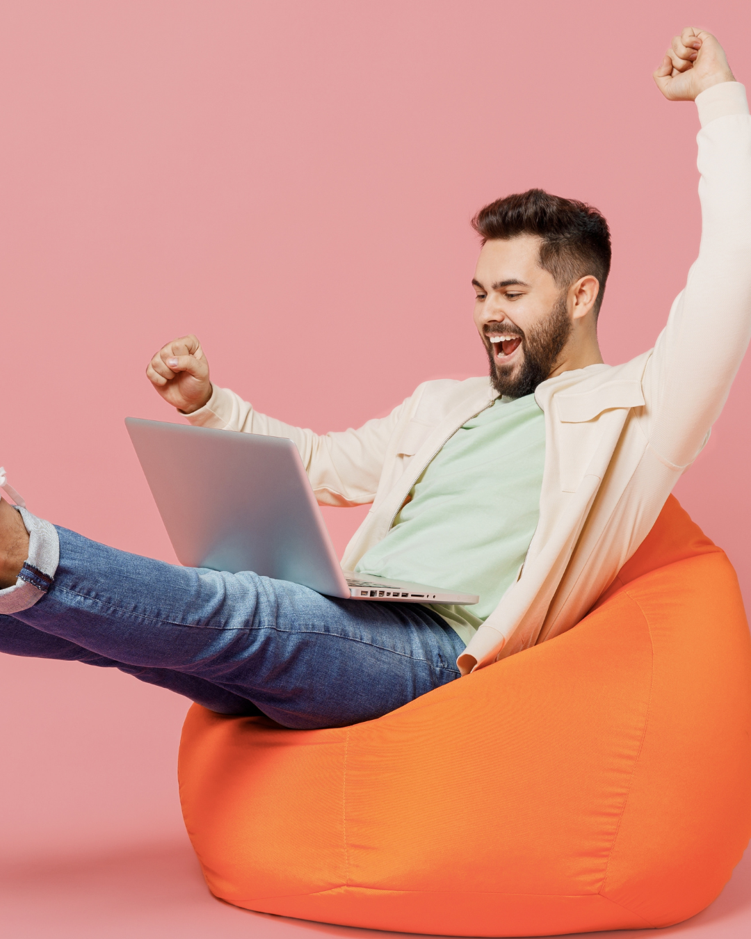 Smiling business professional celebrating while using a laptop, illustrating confidence, achievement and success in running a small business.
