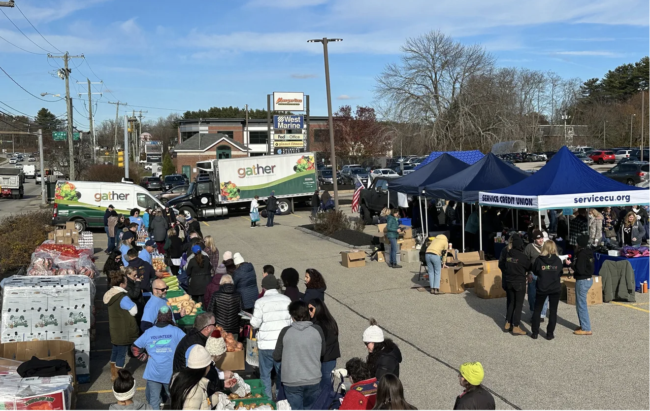 Hundreds of people line up to receive free turkeys and Thanksgiving food from Gather. 