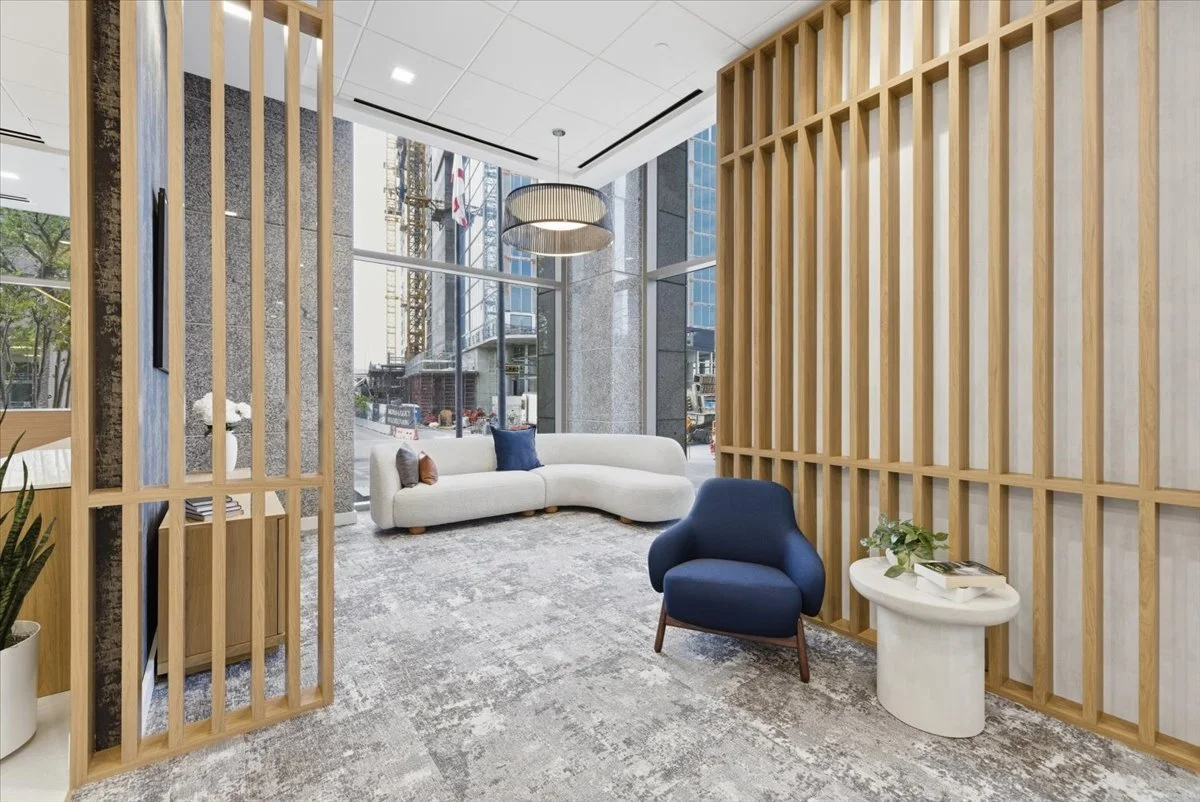 Modern lounge with white curved sofa, blue armchair, small white side table with greenery, large windows, and wooden room dividers.