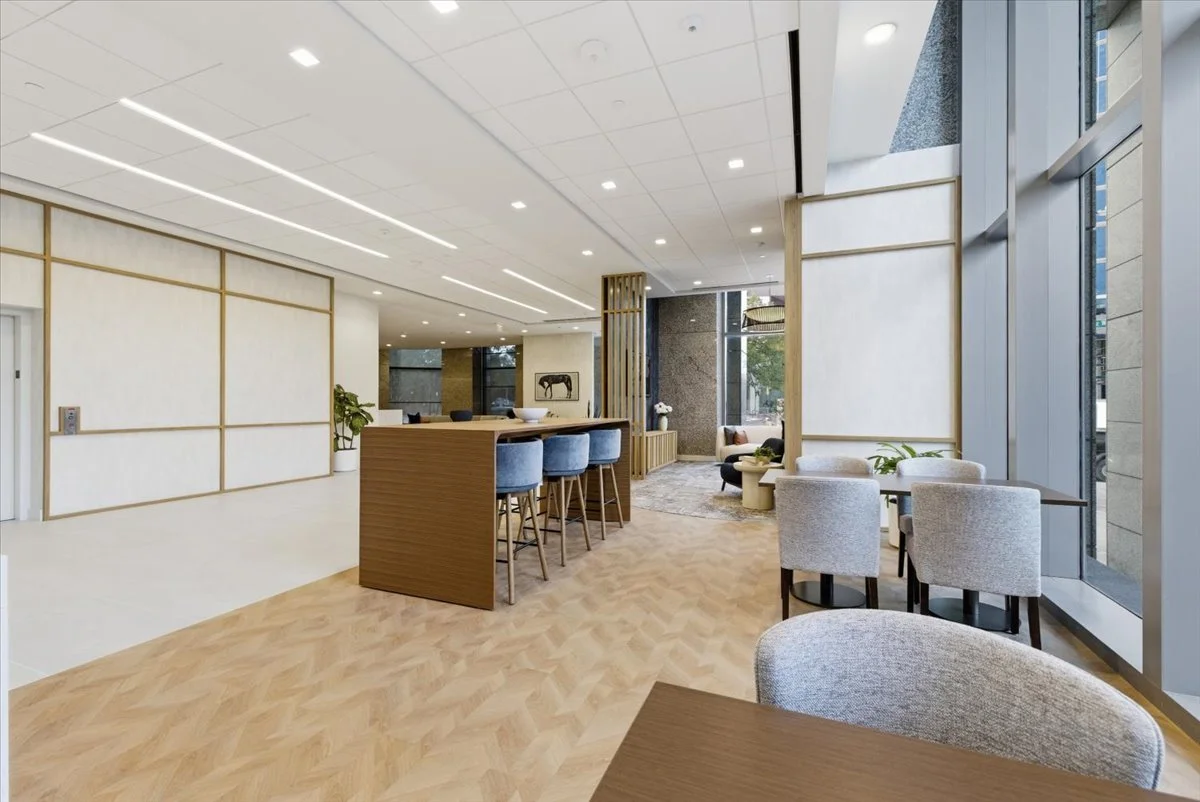 Modern design with seating area, high tables, chairs, and large windows