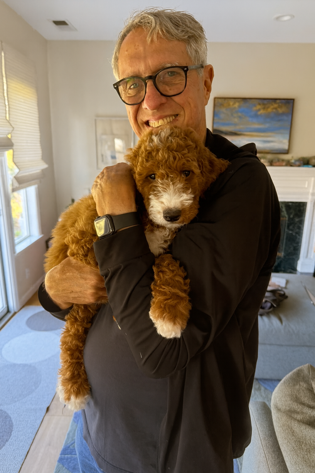 Goldendoodle puppy in the arms of a man smiling