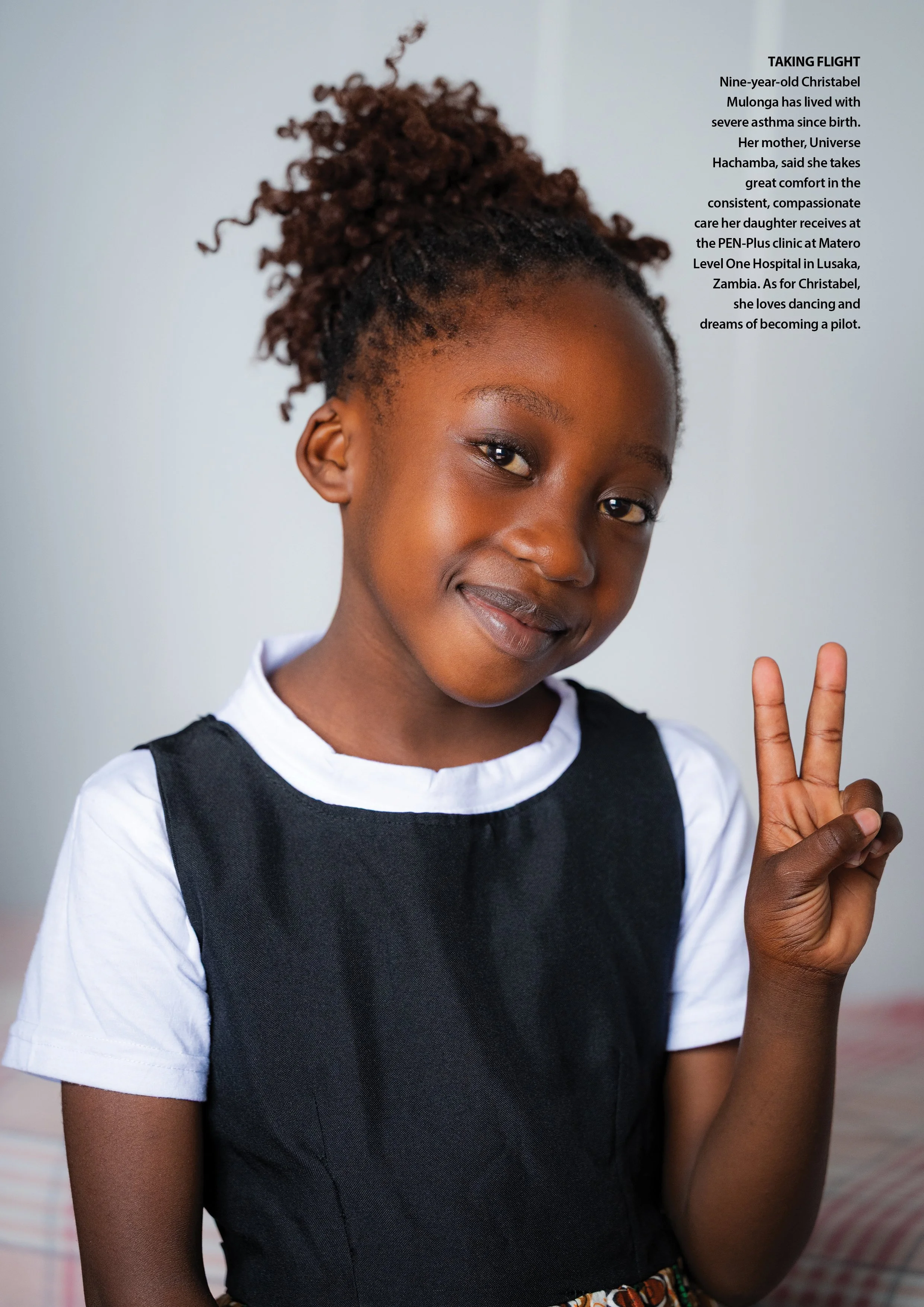 Nine-year-old Christabel makes the peace sign with her fingers