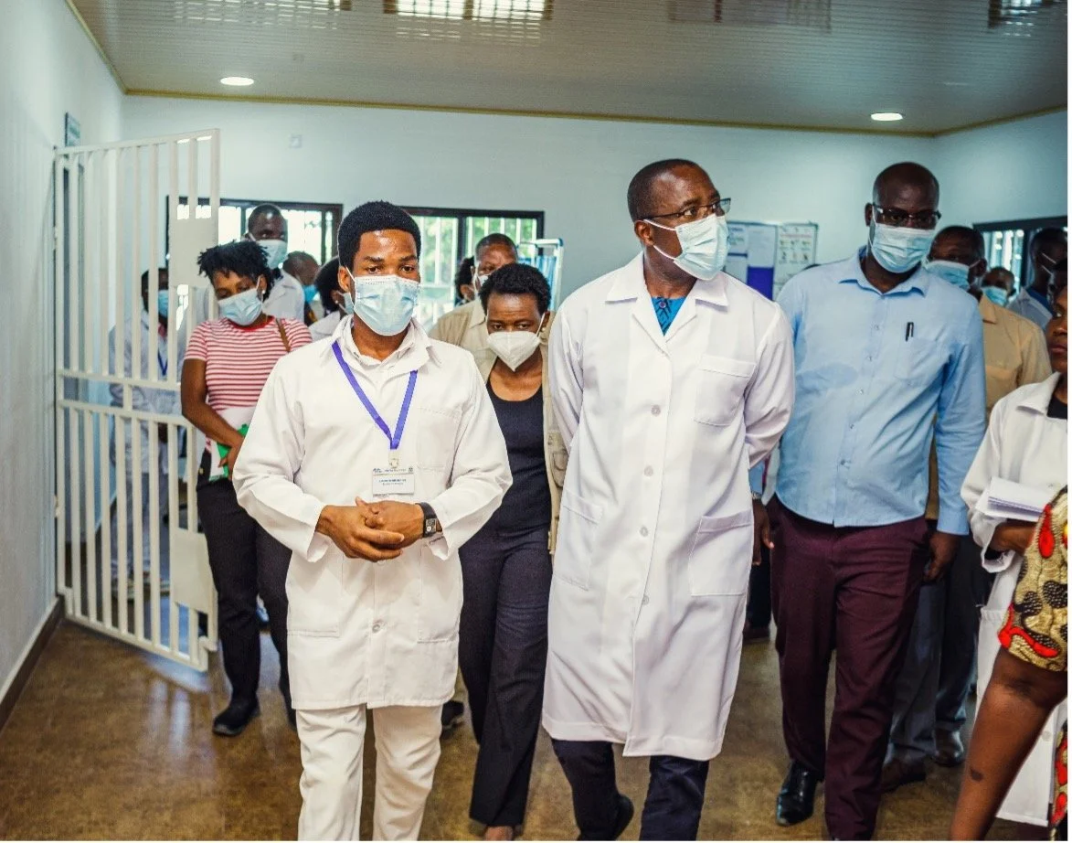 H.E. Dr. Armindo Tiago receives a detailed explanation of the flow of patients inside the clinic from Mr. Lindolfo Baptista, a health provider on staff.