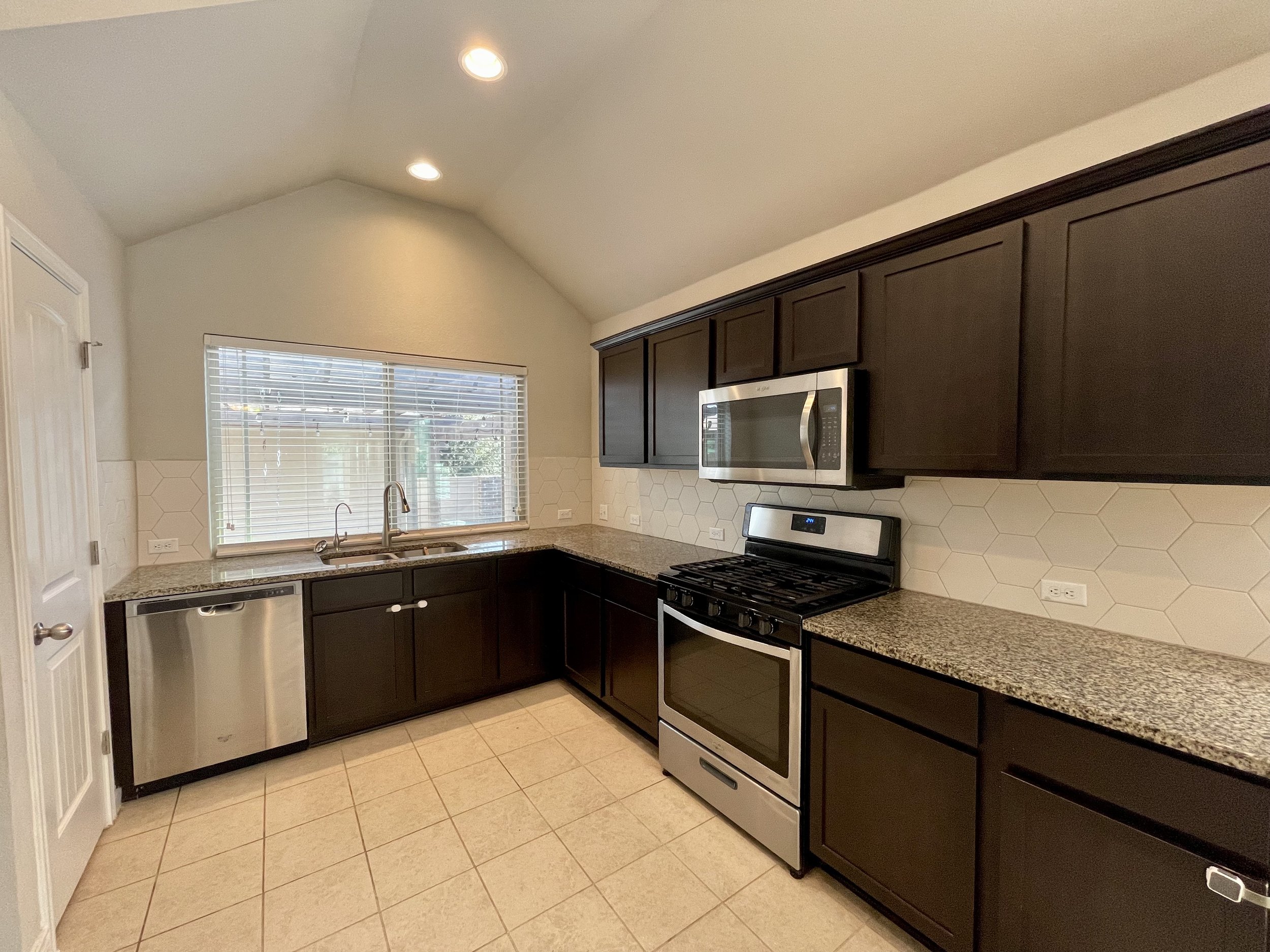 Kitchen has many cabinets and plenty of counter space.