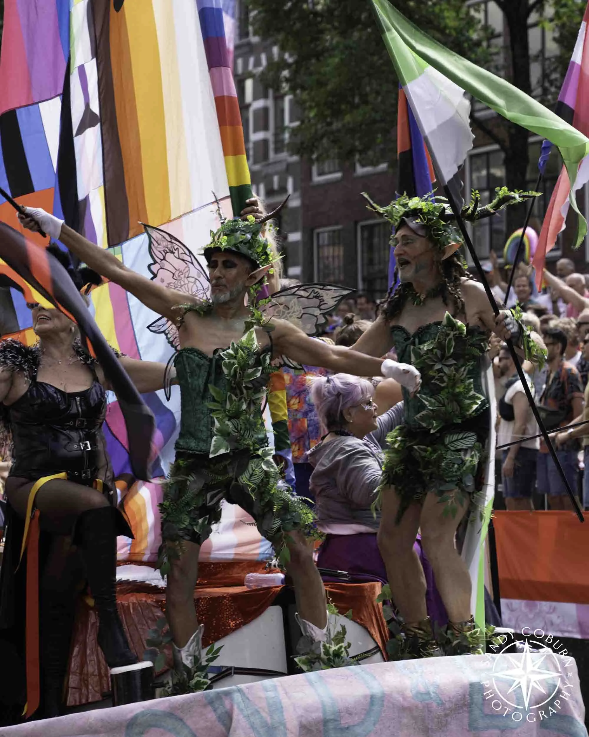 Two people in elf-looking outfits lead a theatre boat at the 2026 WorldPride Amsterdam Canal Parade