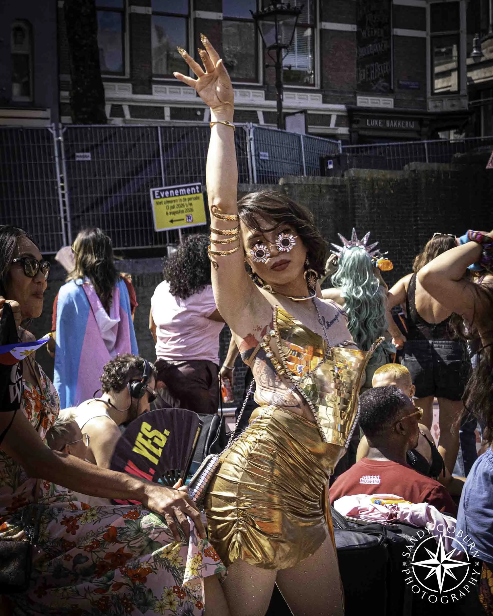 A person in gold poses for a photograph at the 2026 WorldPride Amsterdam Canal Parade