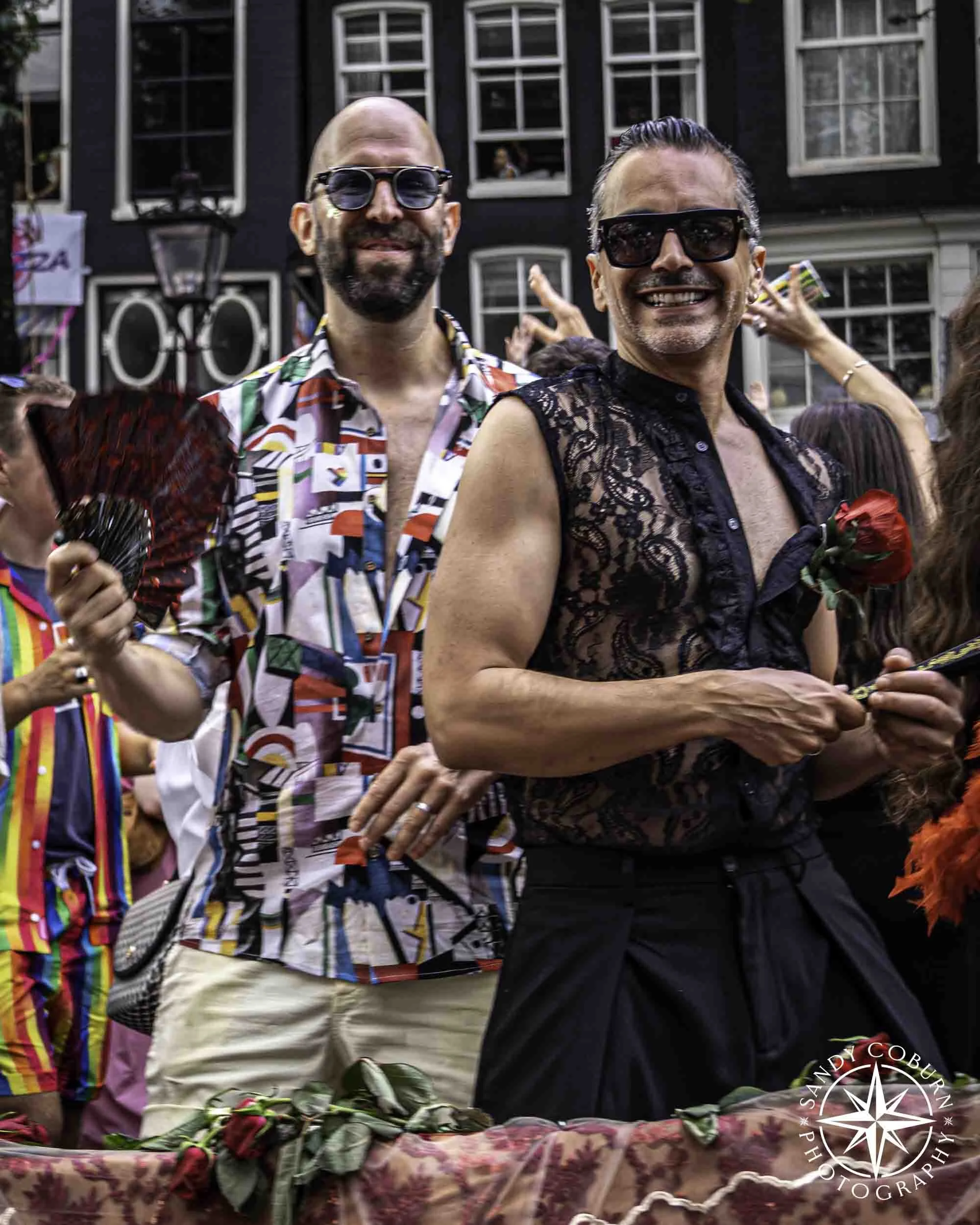 Two participants on the Barcelona Pride boat at the 2026 WorldPride Amsterdam Canal Parade