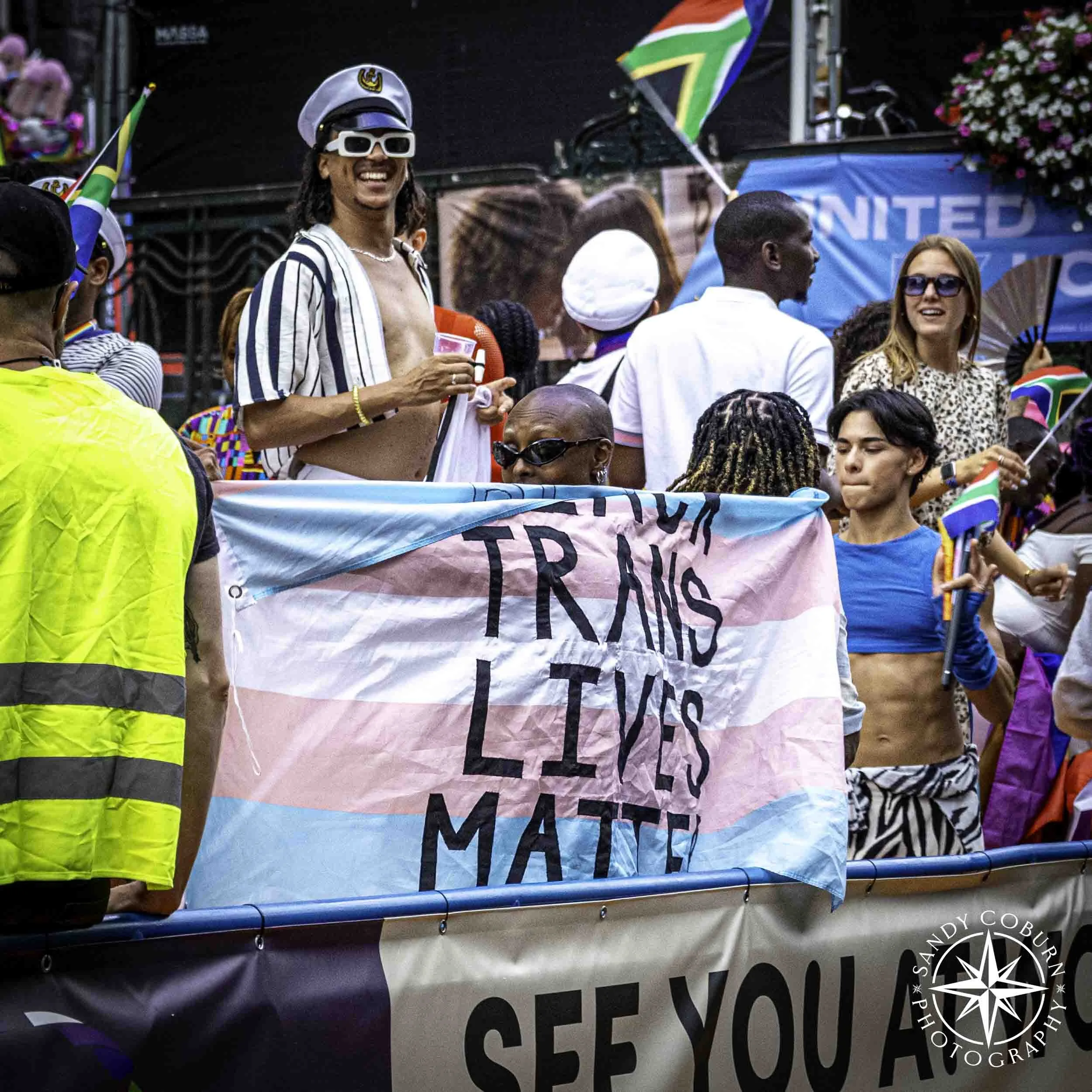 Trans Lives Matter flag as a cape at the 2026 WorldPride Amsterdam Canal Parade