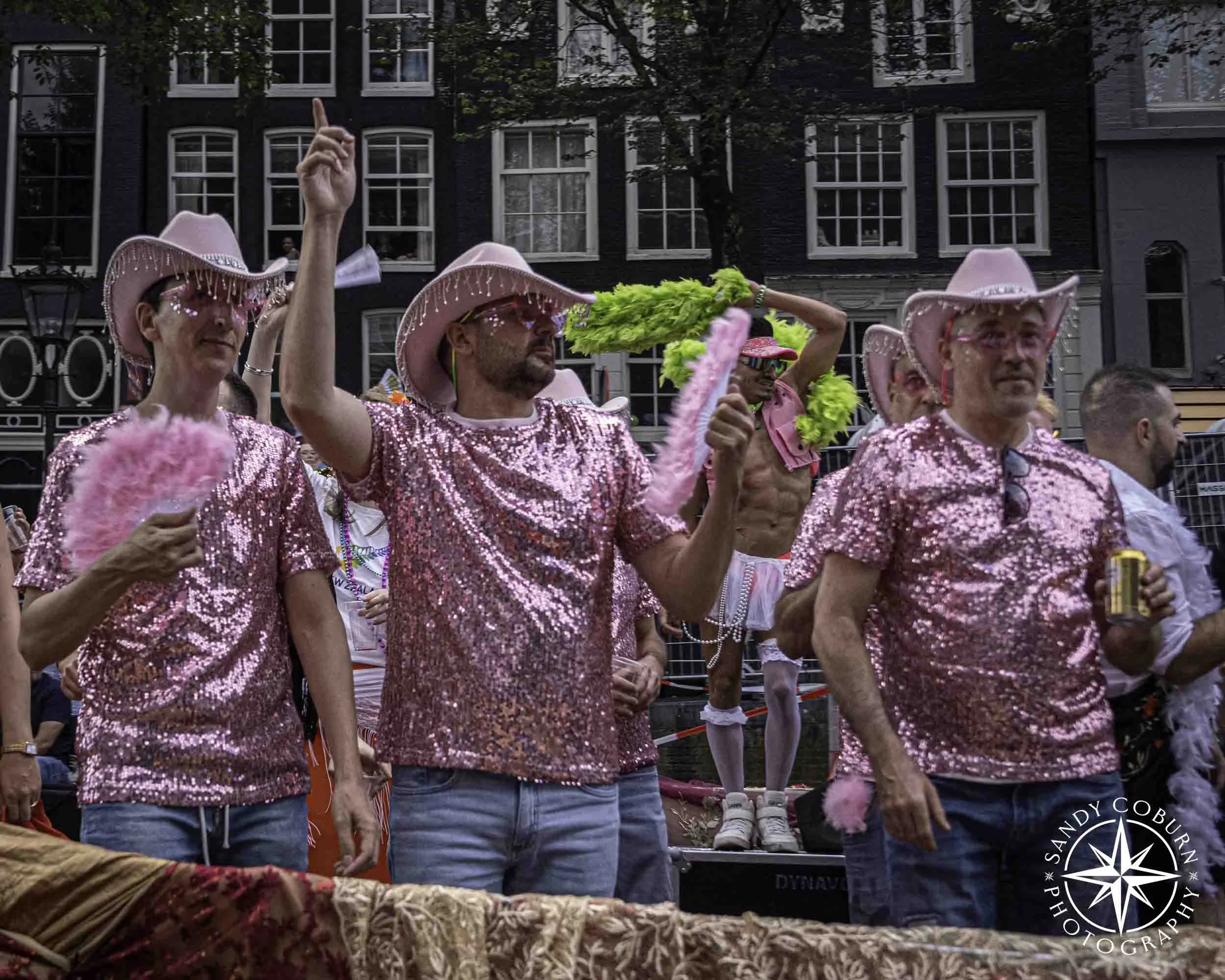 A group of participants in pink sparkles and cowboy hats at the 2026 WorldPride Amsterdam Canal Parade