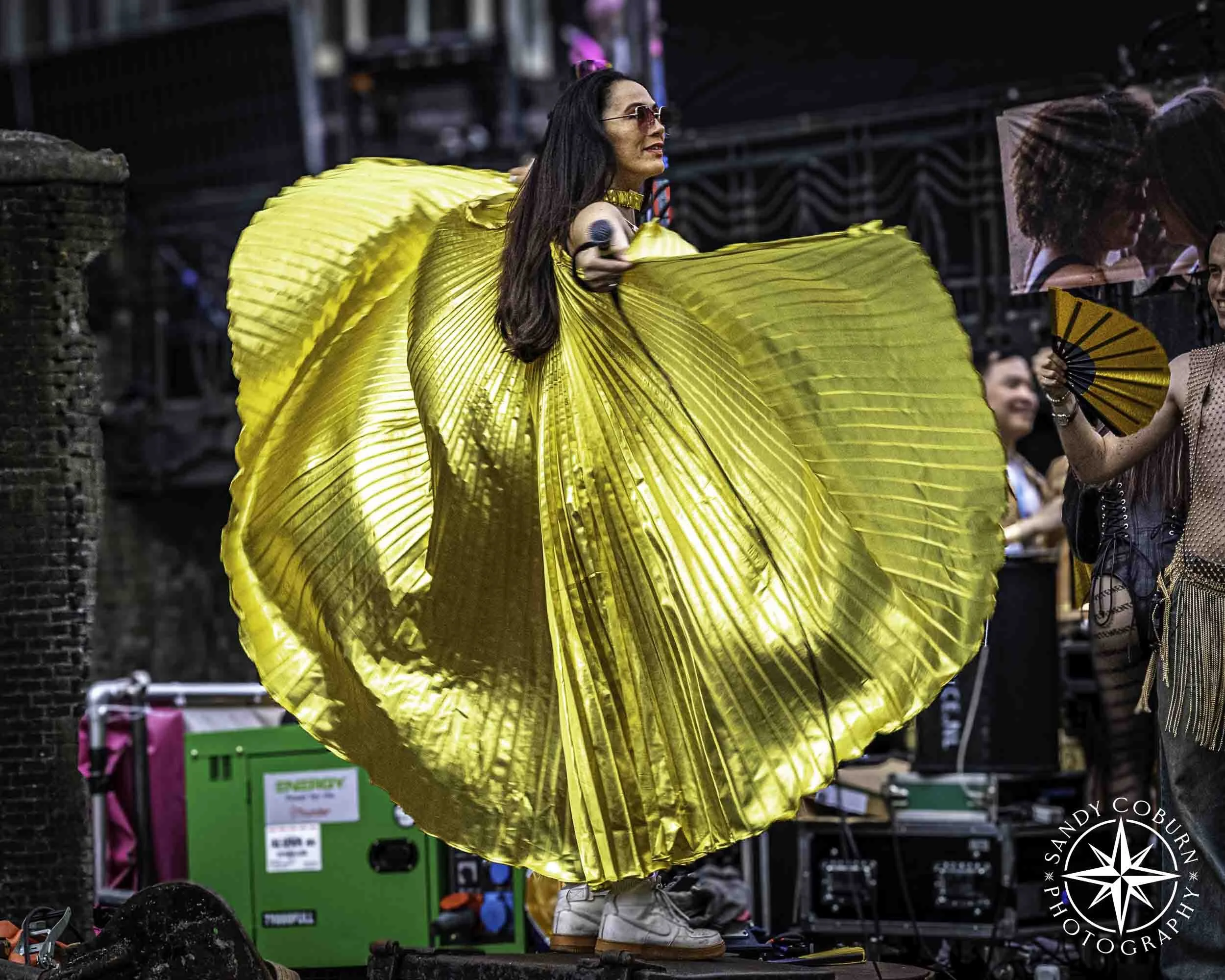 Asian Pride boat participant in a gold cape at the 2026 WorldPride Amsterdam Canal Parade