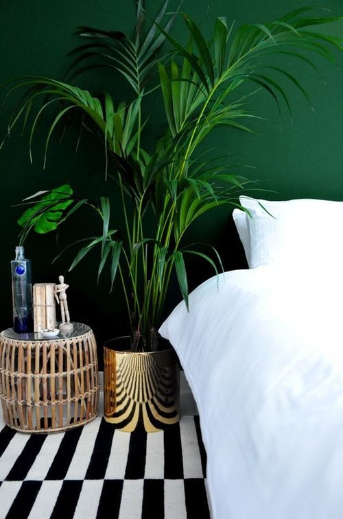 A dark green headboard wall provides a dramatic effect on the room decoration.