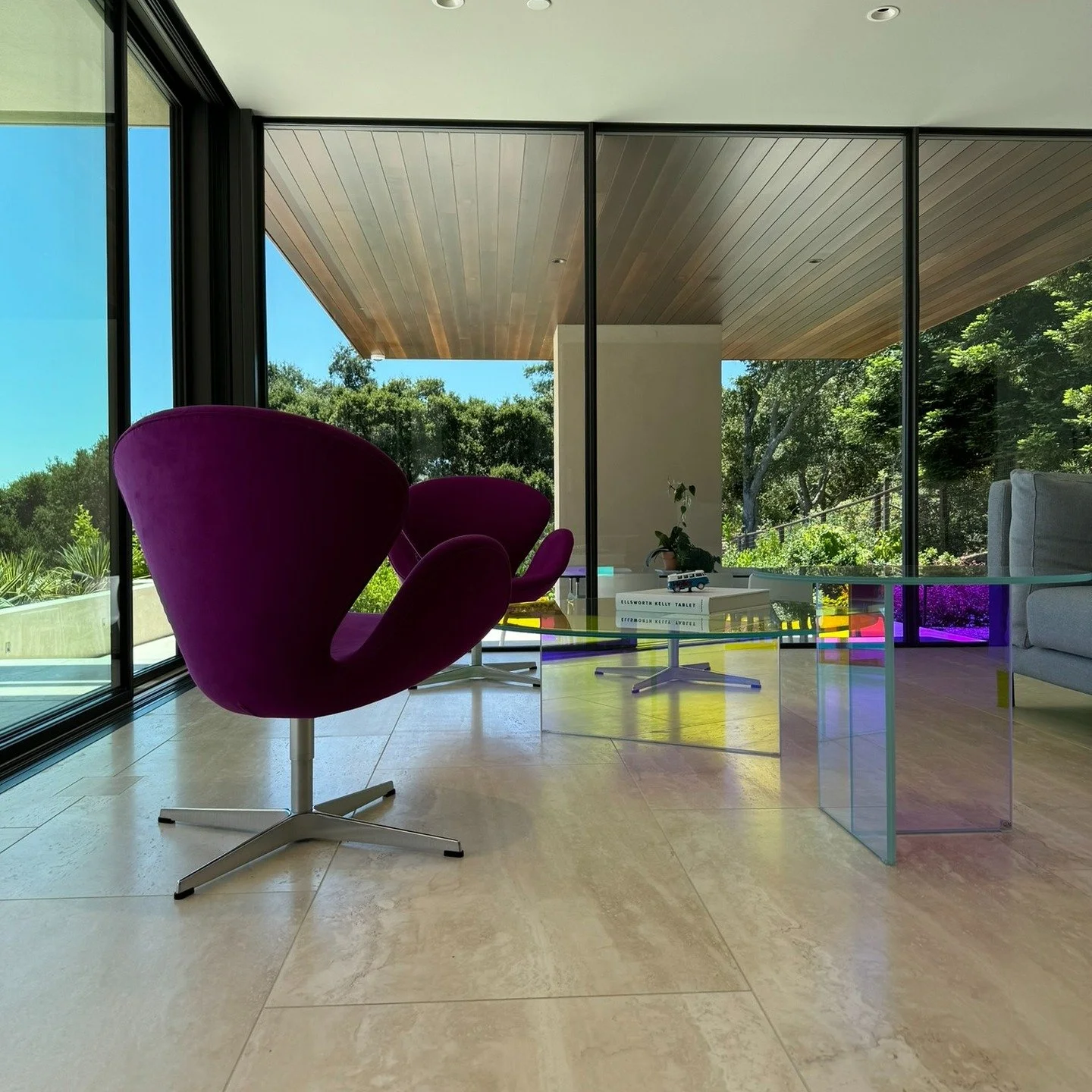 A room where the architecture does most of the talking.
Glass walls, soft stone floors, and a pair of bold lounge chairs catching the light like sculptures. When the outside landscape becomes part of the interior, the whole space feels alive. 💜🌿
.
