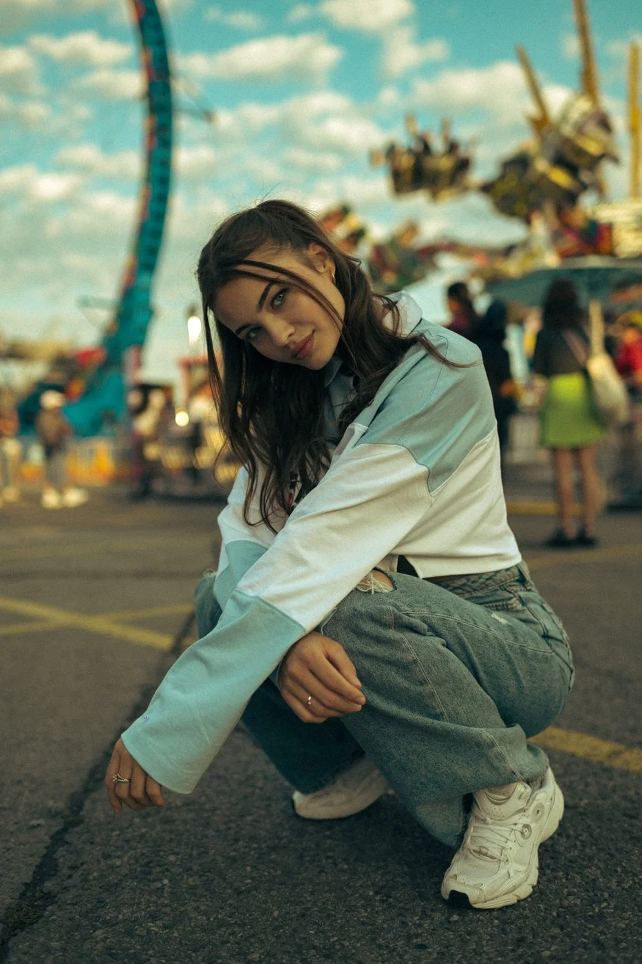 A playful crouching portrait at a fairground