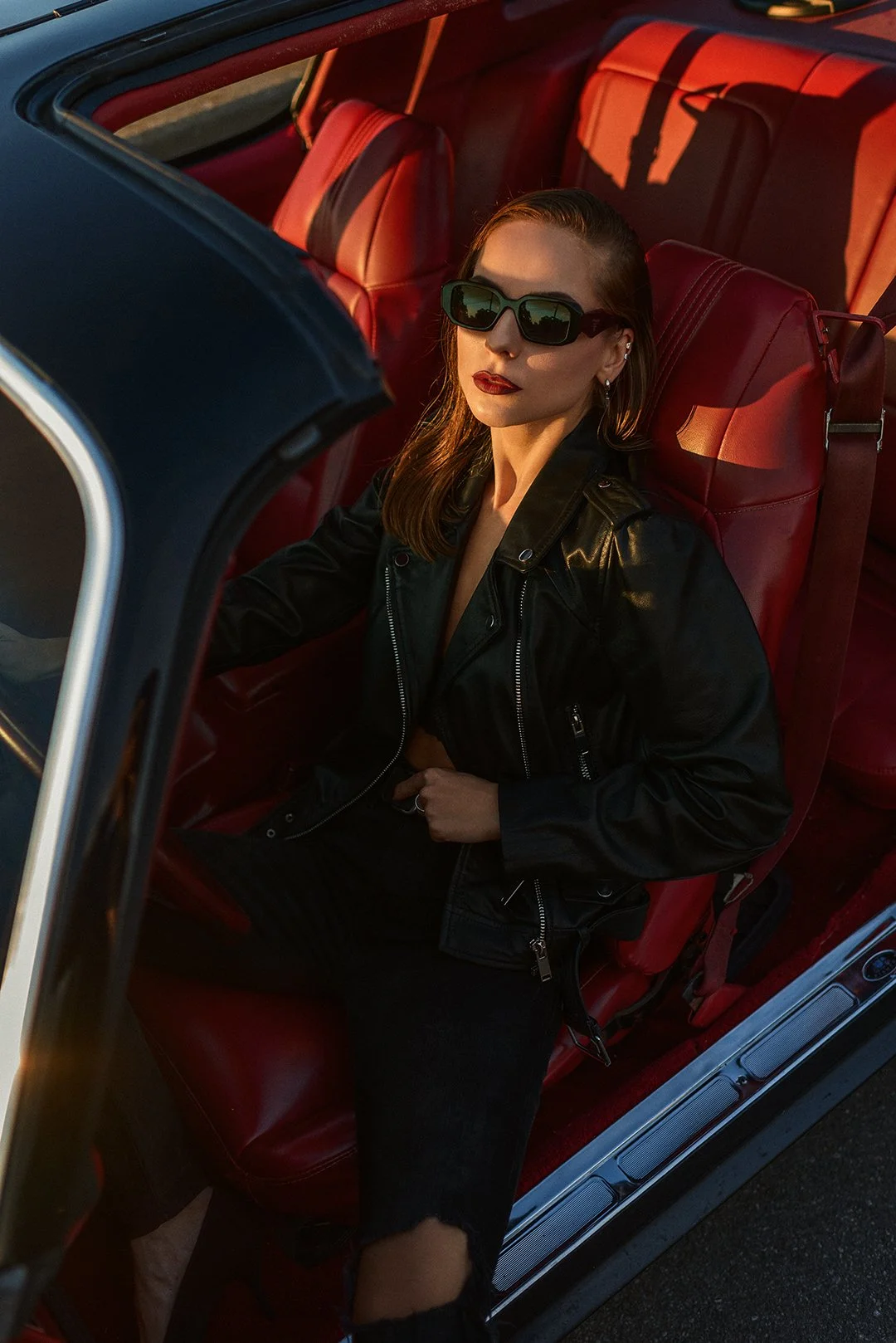 Lifestyle portrait in a black leather jacket inside a car