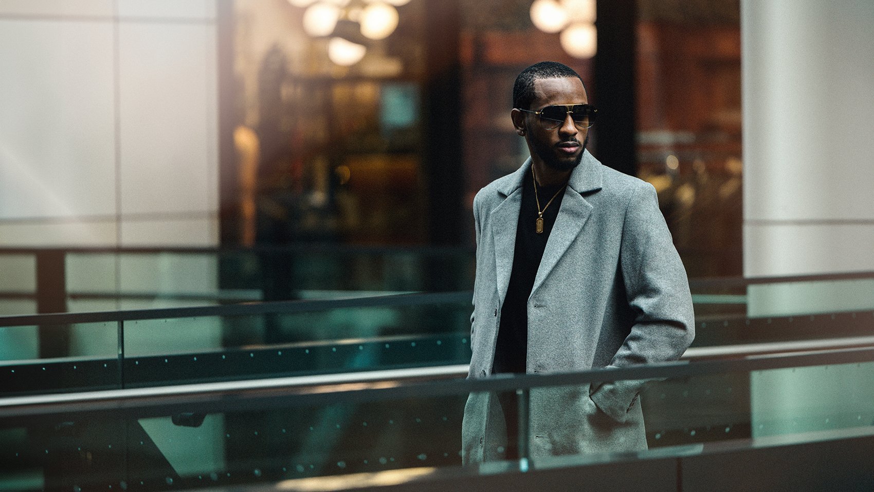 A man in a light blazer against modern city architecture