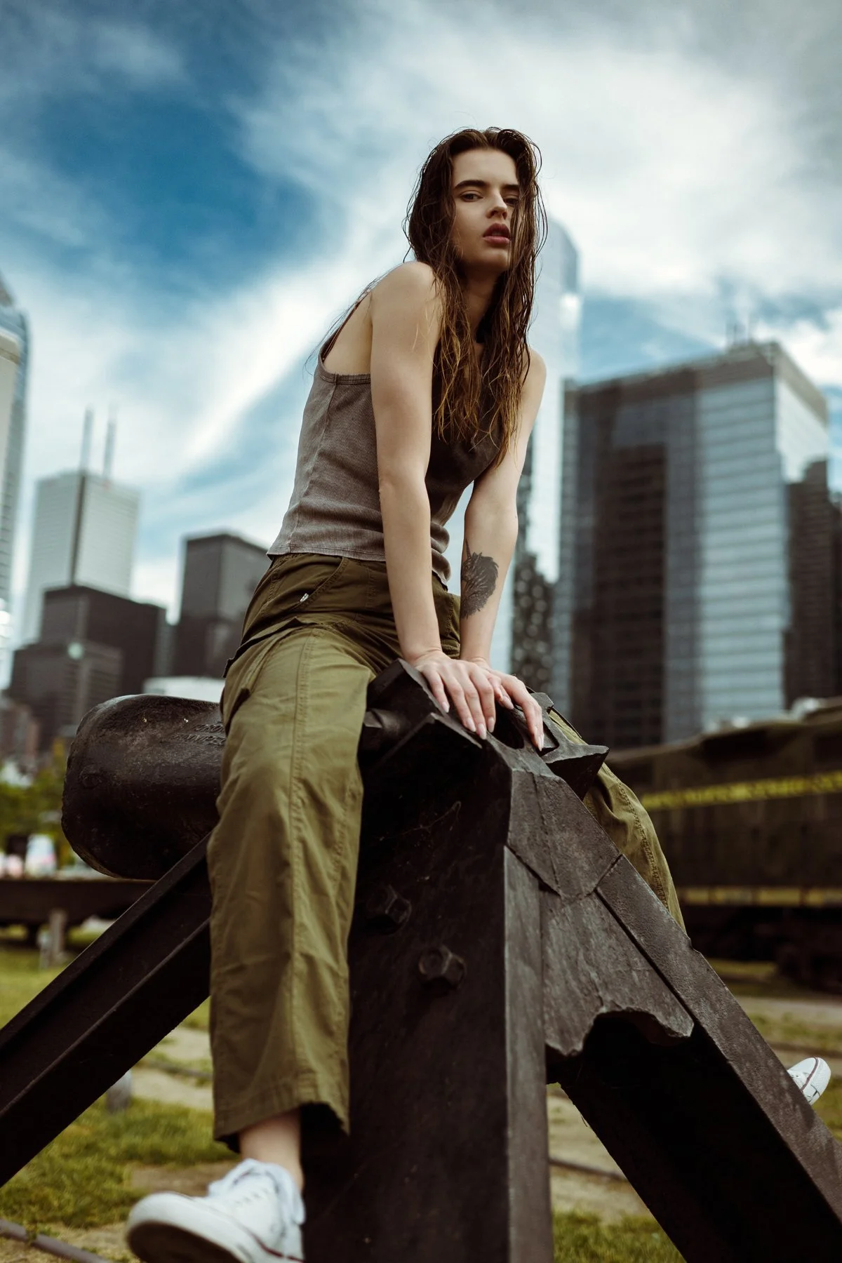 A portrait framed by a timber railing and the city skyline