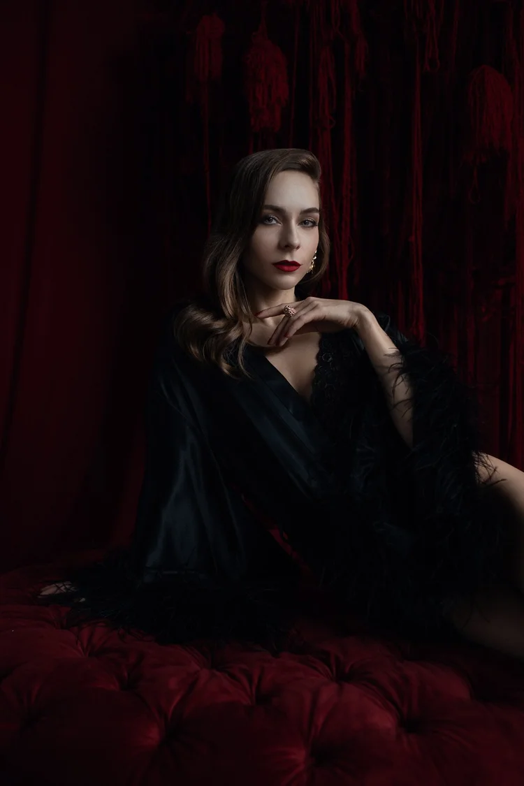 Moody boudoir portrait in a deep red room