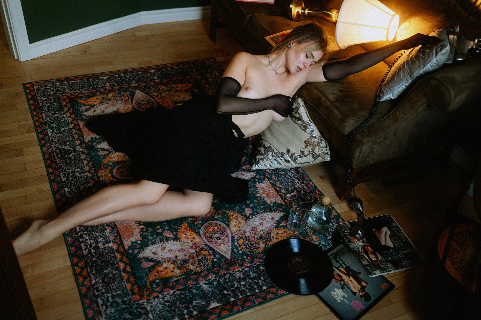 Overhead boudoir portrait with dramatic shadows, warm lamp light, and vintage living room details
