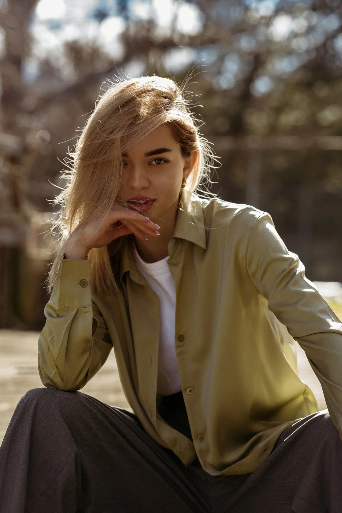 A seated outdoor portrait in a pale green shirt