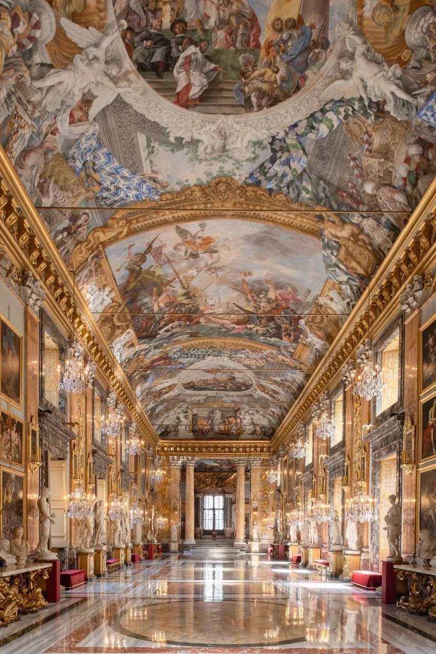 Opulent palace hall with ornate gold accents, marble statues, and elaborate ceiling frescoes depicting mythological scenes.