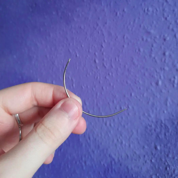 Curved needle, age unknown.