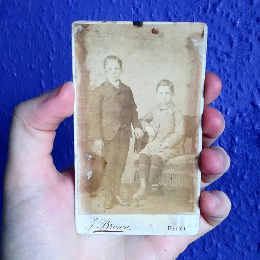 Weathered photo of two young boys, late 19th Century, shot by J. Brown