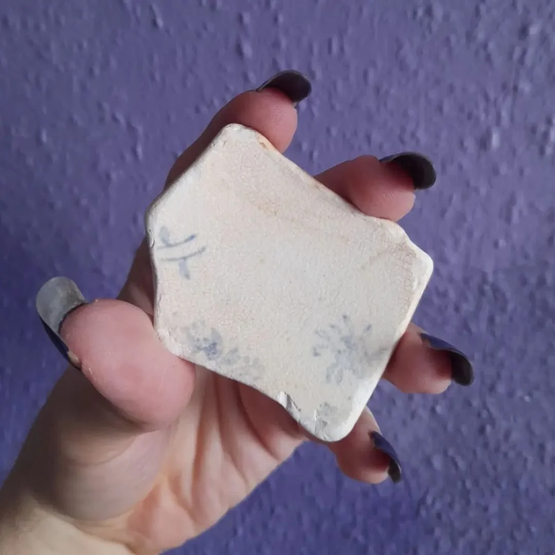 Piece of white pottery with faded blue pattern, age unknown.